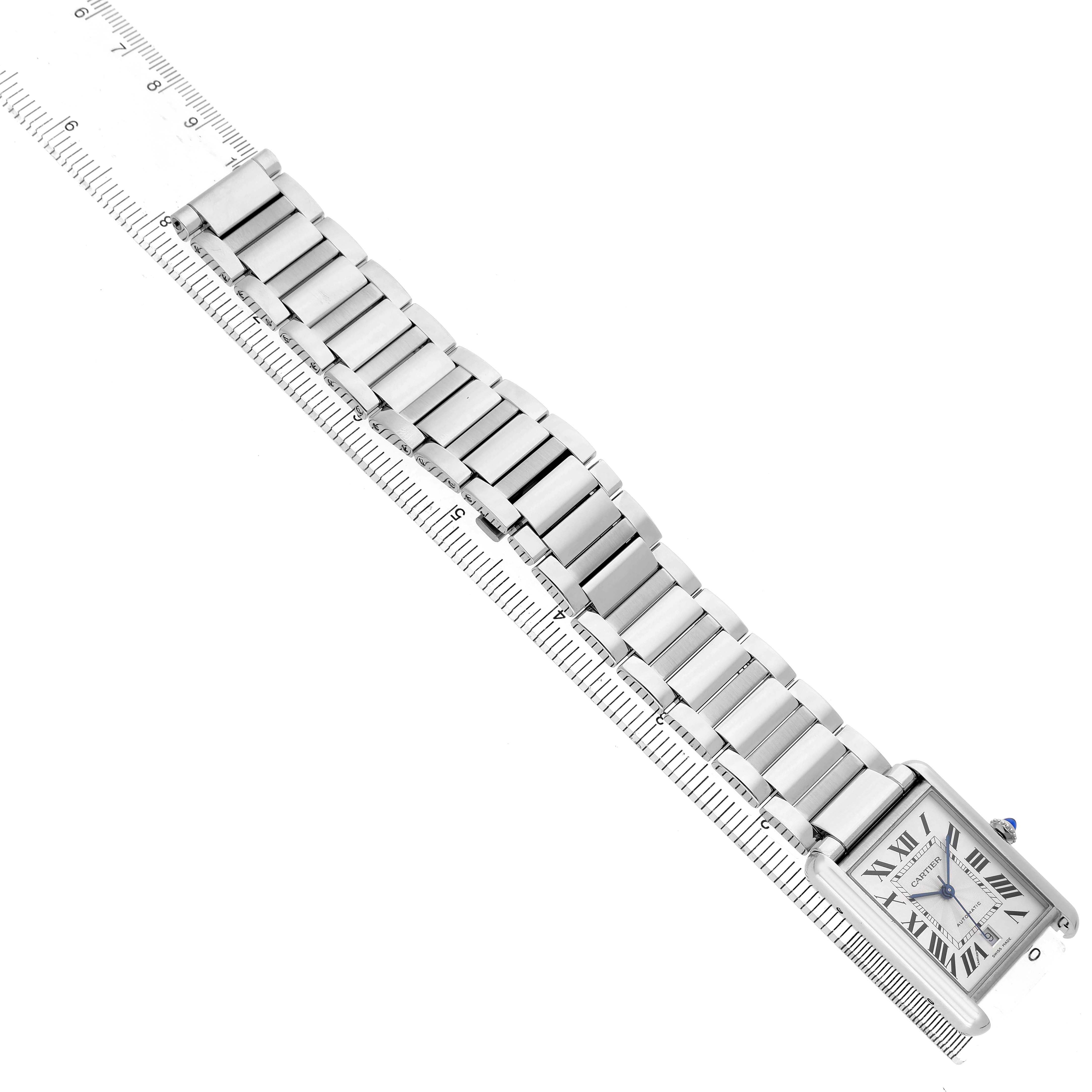 The Cartier Tank Must WSTA0053 Men's Stainless Steel Silver Dial model watch is shown from a top-down angle, displaying the face, bracelet, and a ruler for scale.