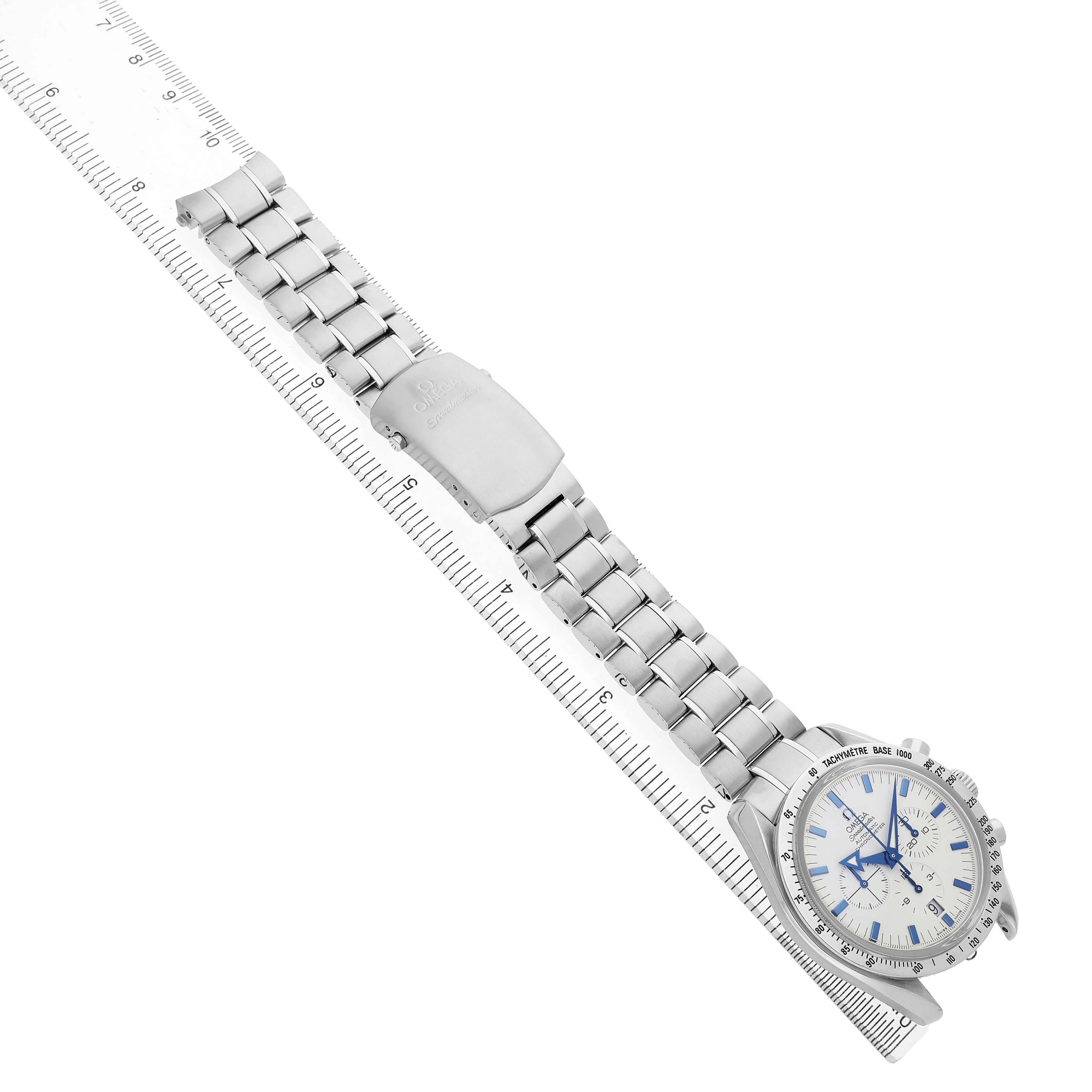 The Omega Speedmaster 3551.20.00 Men's Stainless Steel White Dial watch is shown diagonally with its face, bracelet, and clasp visible, aligned with a ruler.