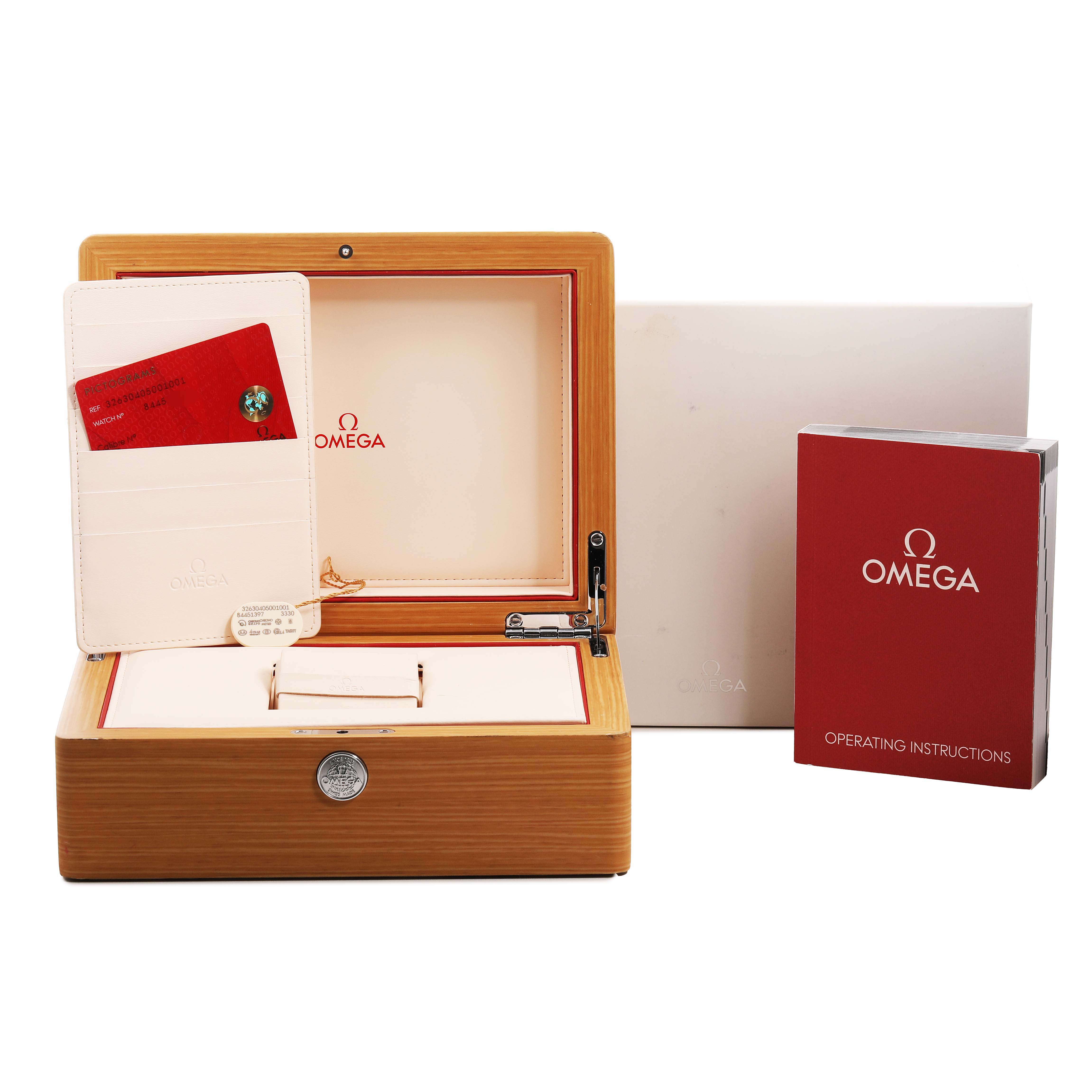 The image shows an Omega Speedmaster 326.30.40.50.01.001 Men's Stainless Steel Black Dial box set with an open wooden case, a warranty card holder, and operating instructions.