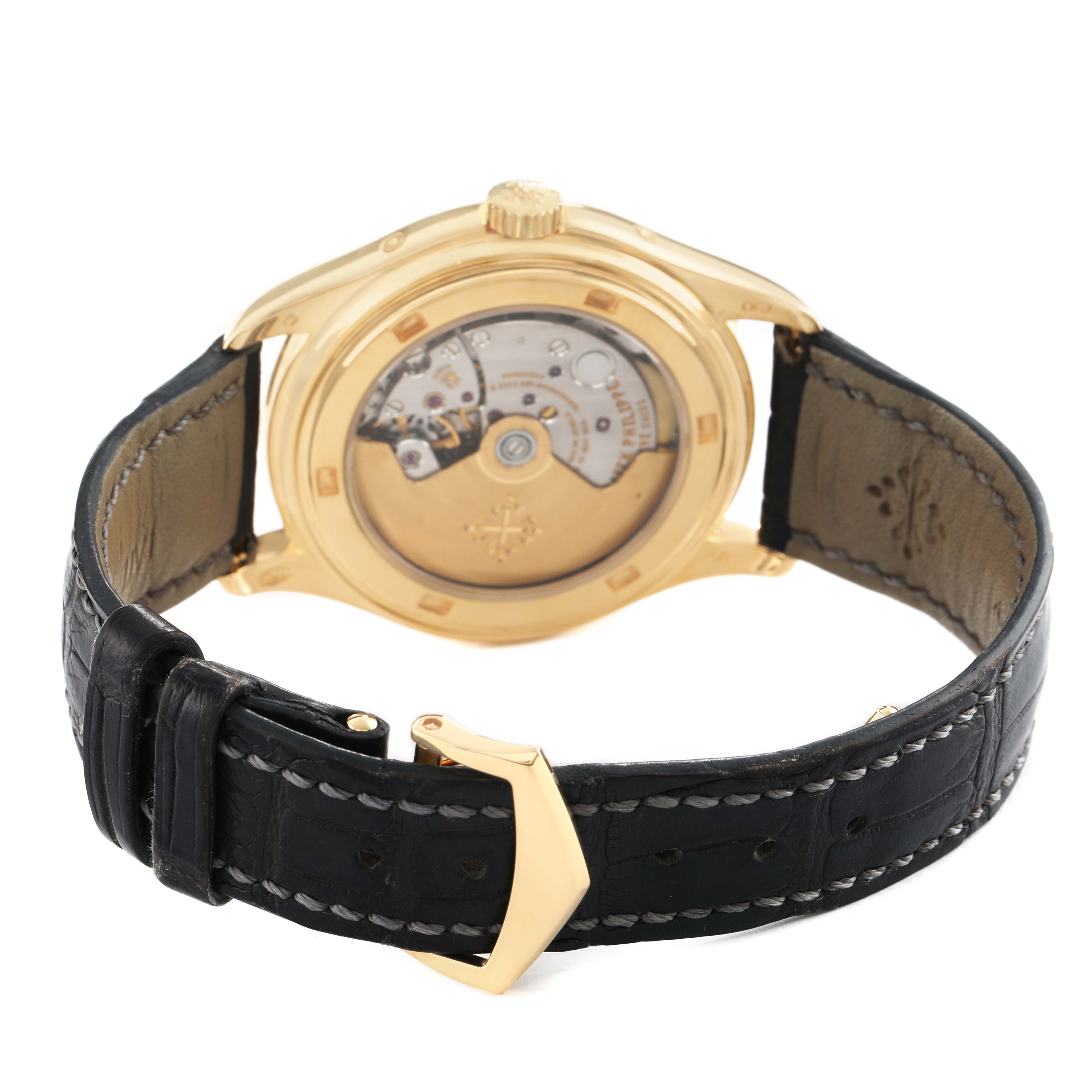 The image shows the back of a Patek Philippe Complications 5146J Men's Yellow Gold White Dial watch, displaying its movement and leather strap.