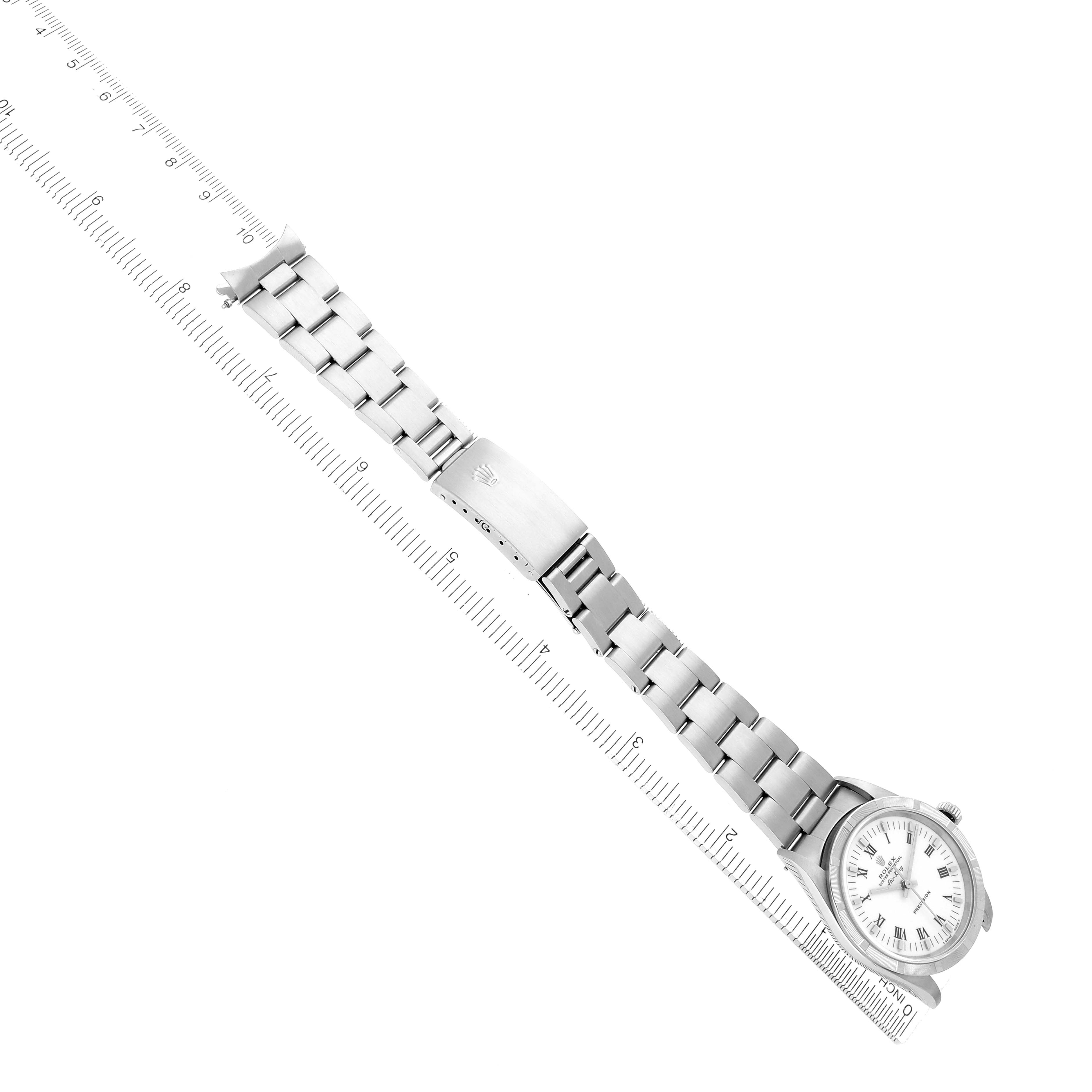 The Rolex Air-King 14010 Men
s Stainless Steel White Dial watch is shown at an oblique angle, displaying the dial and full metal bracelet alongside a measuring ruler.
