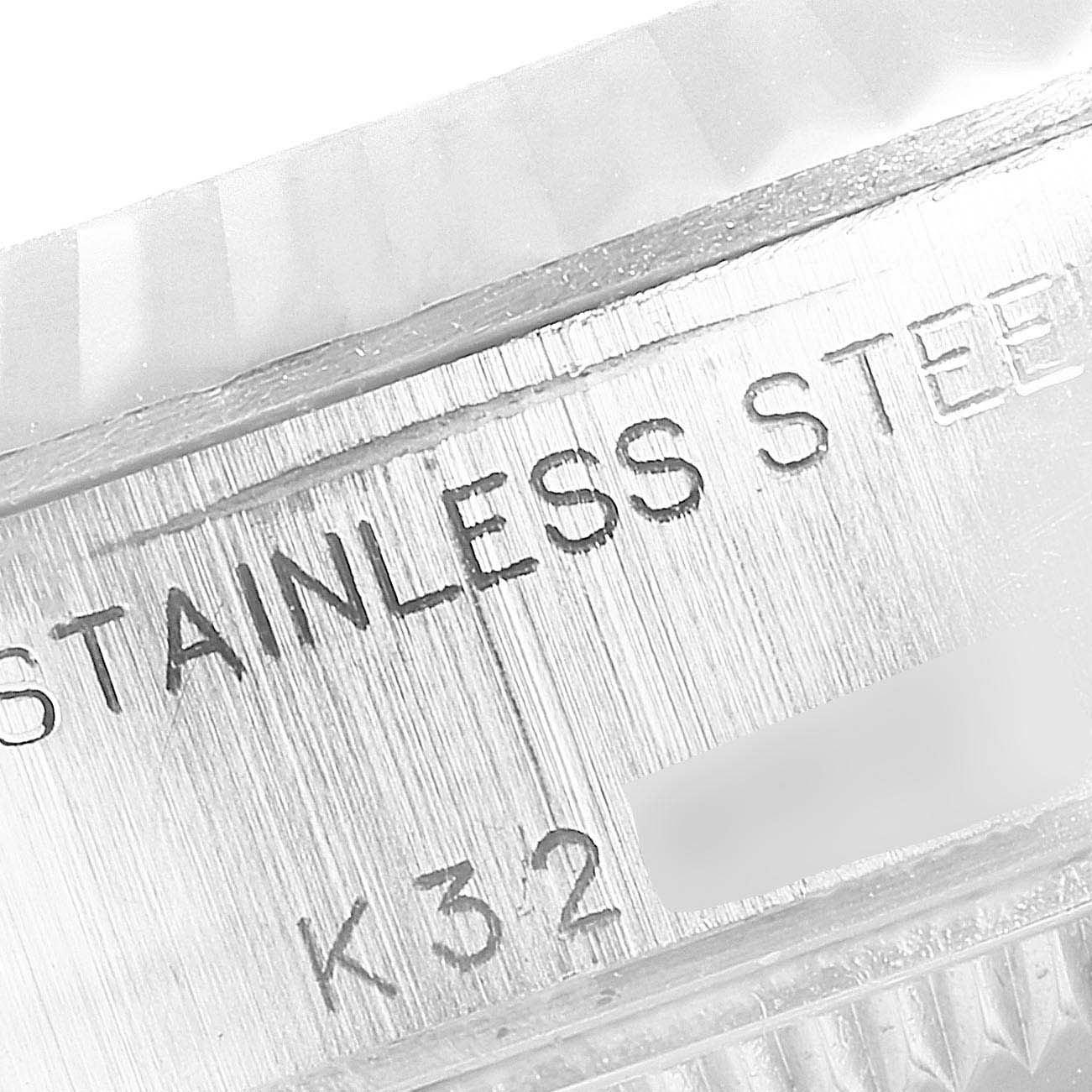 The image shows a close-up view of the "STAINLESS STEEL" engraving on the case of a Rolex Datejust 79174 Women's Stainless Steel Black Dial 79174 Women's Stainless Steel Black Dial model.