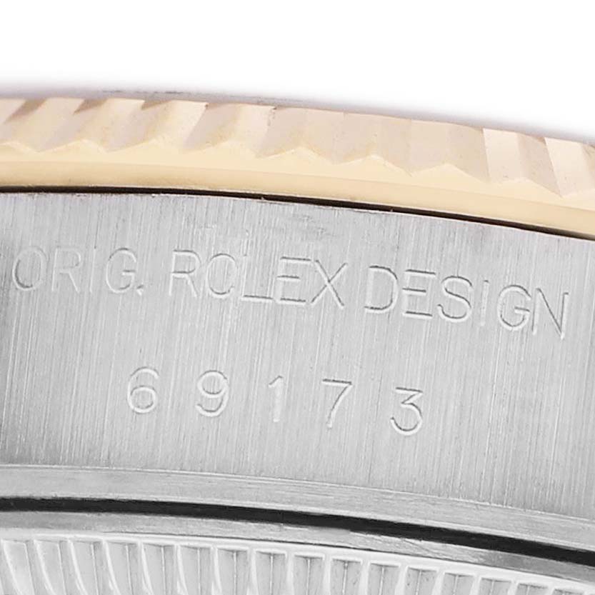 The image shows a close-up of the case side engraving on a Rolex Datejust 69173 Women's Steel and Gold (two tone) Champagne Dial, displaying the model number and design text.