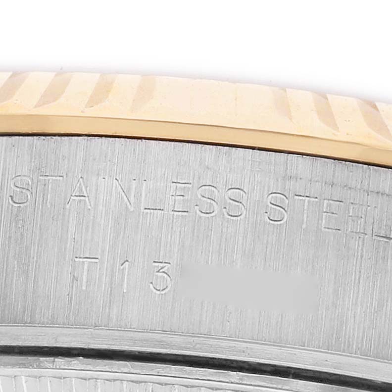 The image shows a close-up of the stainless steel part and bezel of a Rolex Datejust 69173 Women's Steel and Gold (two tone) Champagne Dial watch, focusing on the engraved text.