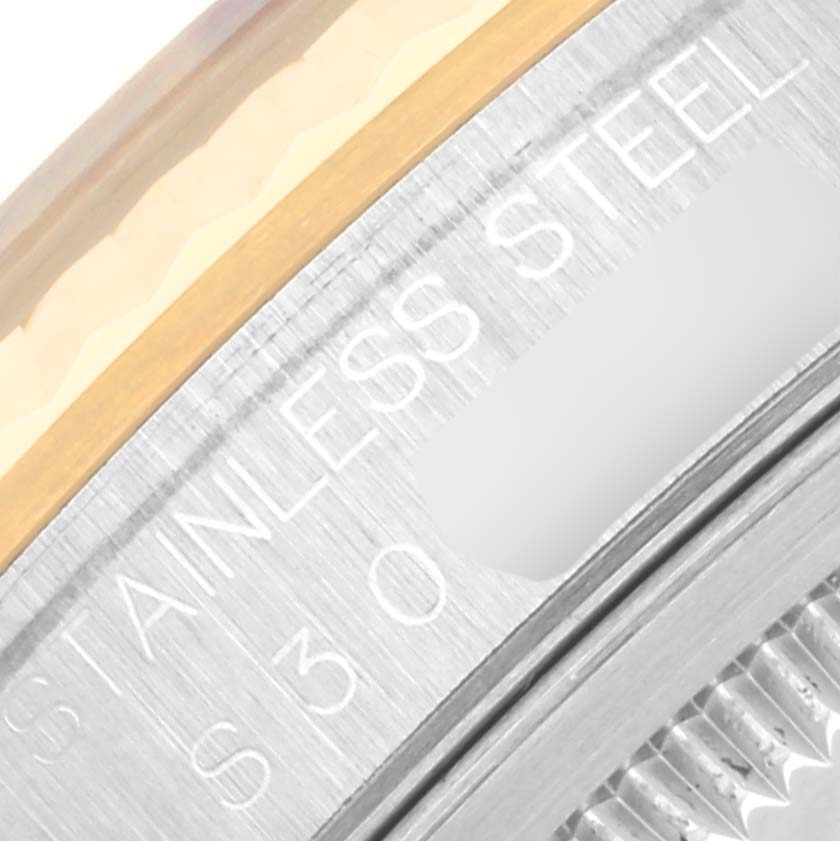 This image shows a close-up of the bezel and part of the case of a Rolex Datejust 16233 Men's Steel and Gold (two tone) Black Dial 16233 Men's Steel and Gold (two tone) Black Dial watch, highlighting the "Stainless Steel" engraving.