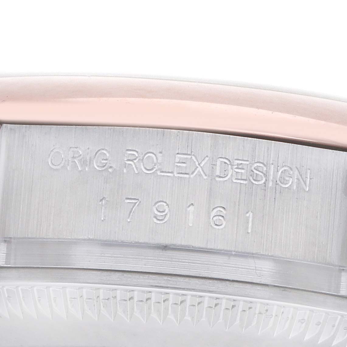 The image shows a close-up of the side of a Rolex Datejust 179161 Women
s Steel and Gold (two tone) Pink Dial case, featuring engraved design details and model number.