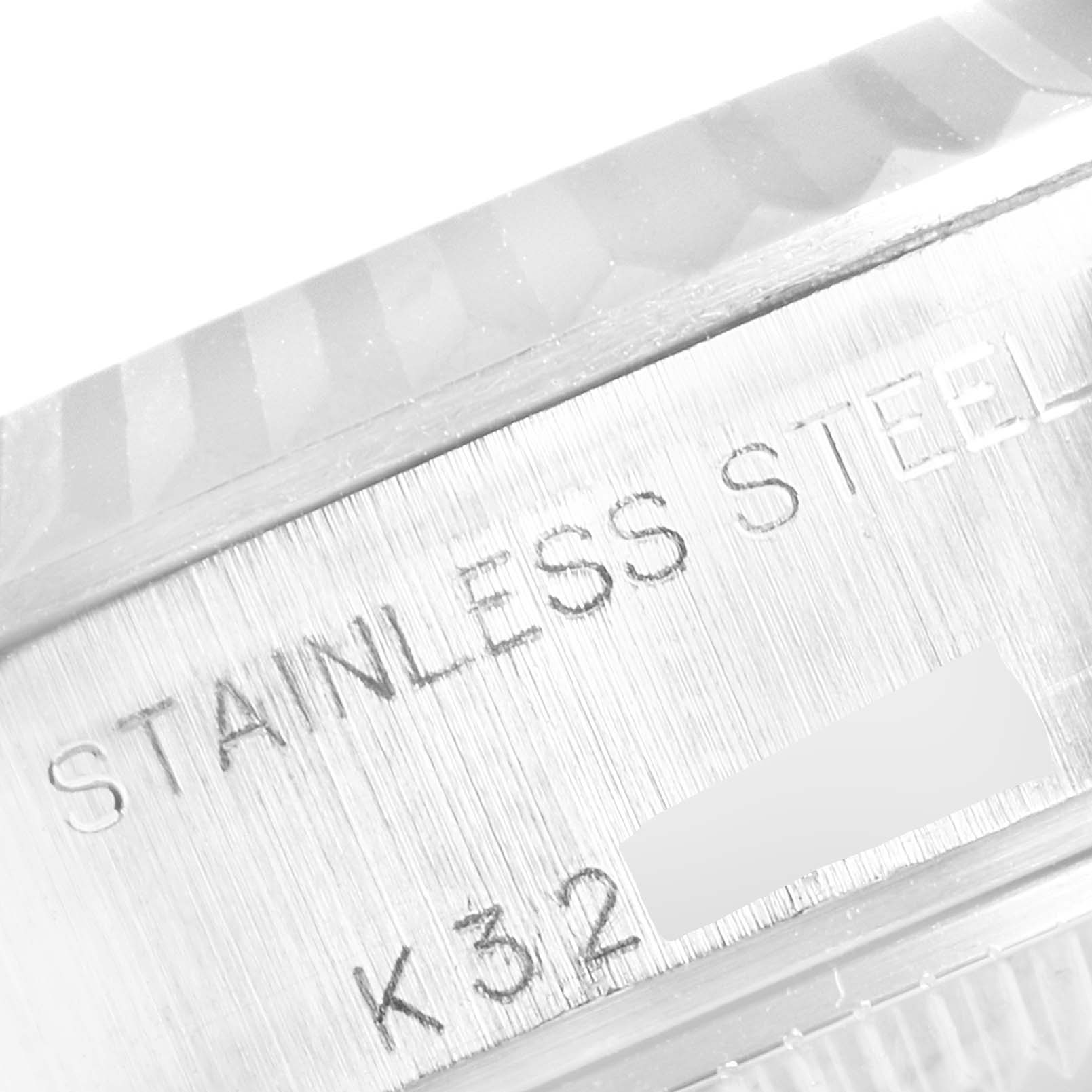 This close-up image shows part of the stainless steel case back of a Rolex Datejust 79174 Women
s Stainless Steel Silver Dial 79174 Women
s Stainless Steel Silver Dial watch with engraved text.
