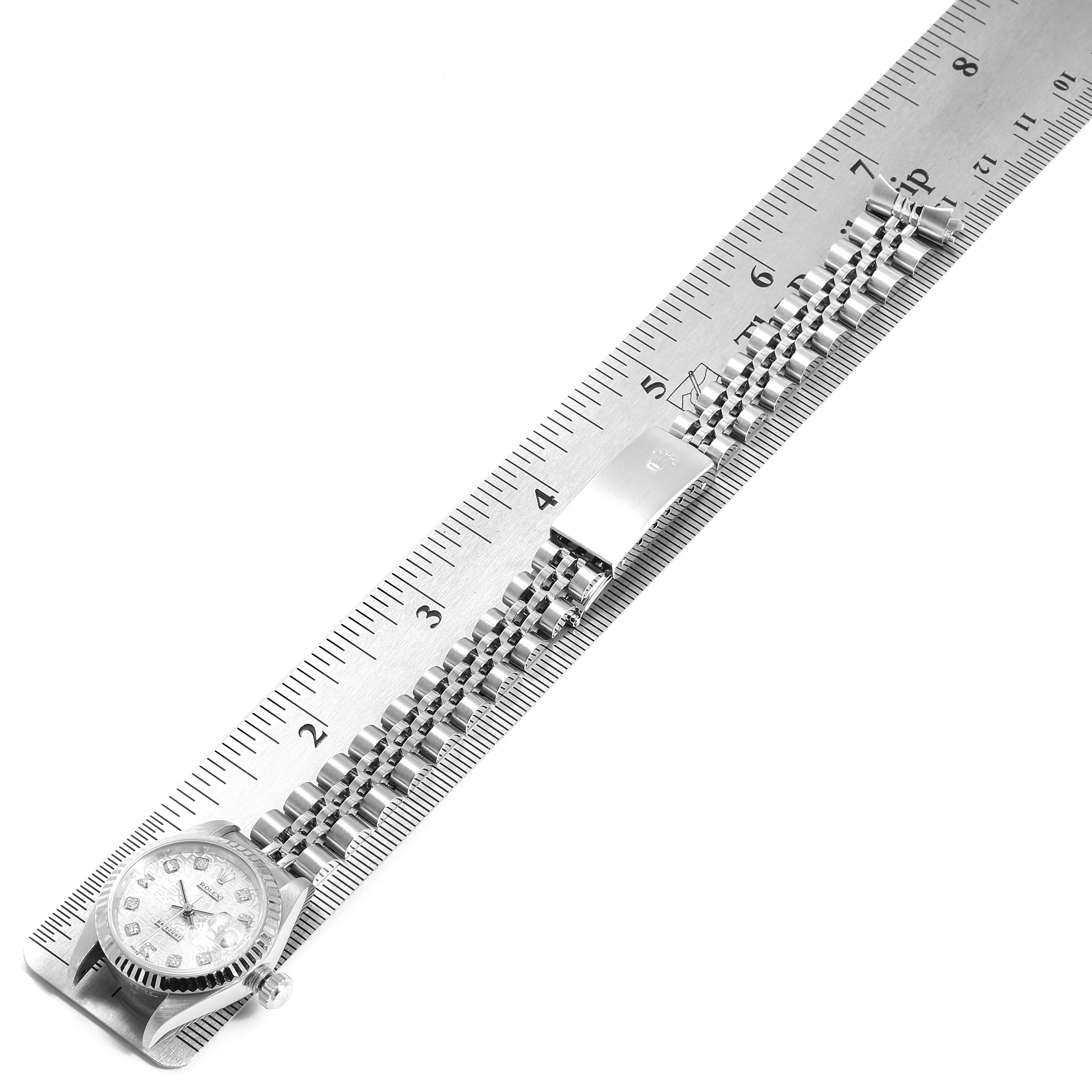 The image shows a Rolex Datejust 79174 Women
s Stainless Steel Silver Dial 79174 Women
s Stainless Steel Silver Dial watch laid flat with its bracelet fully extended next to a ruler.