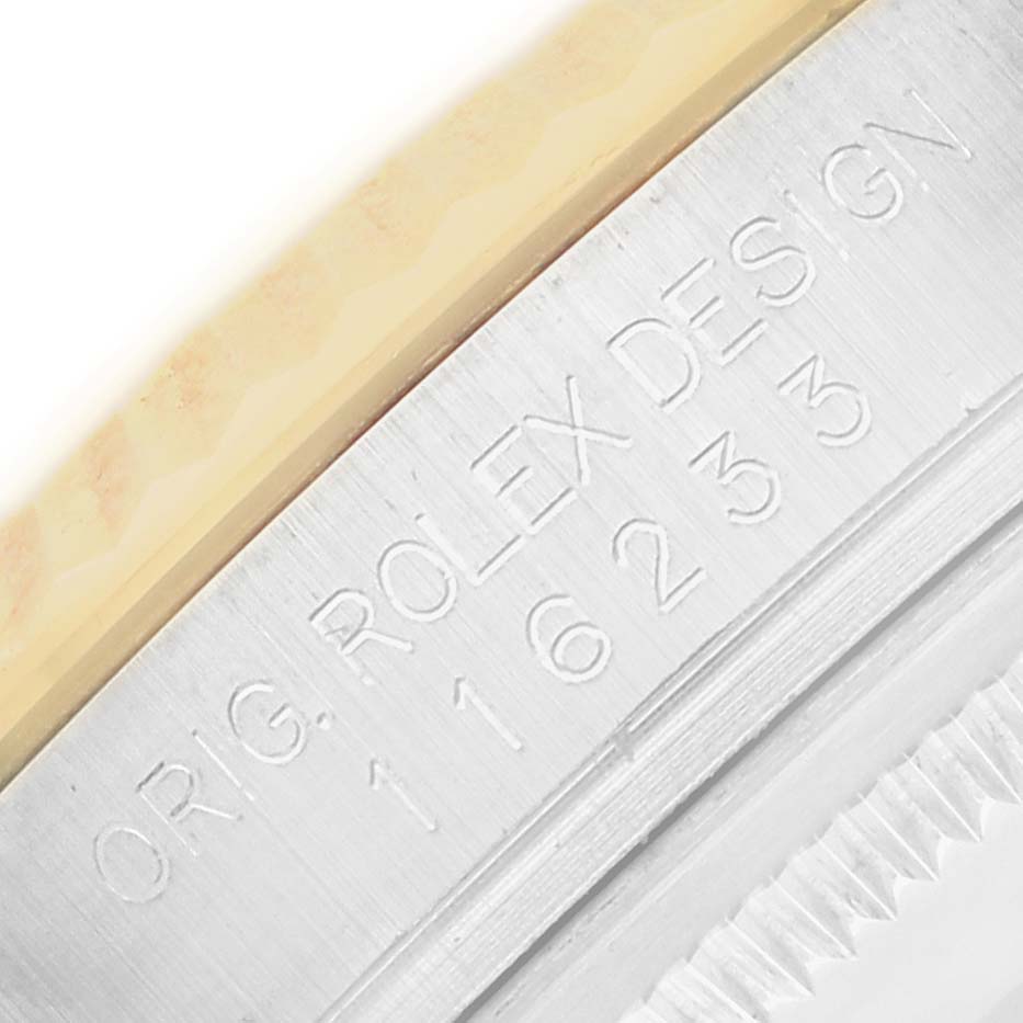 The image shows a close-up of the side of a Rolex Datejust 116233 Men
s Steel and Gold (two tone) Champagne Dial, highlighting the engraved model number on the case edge.