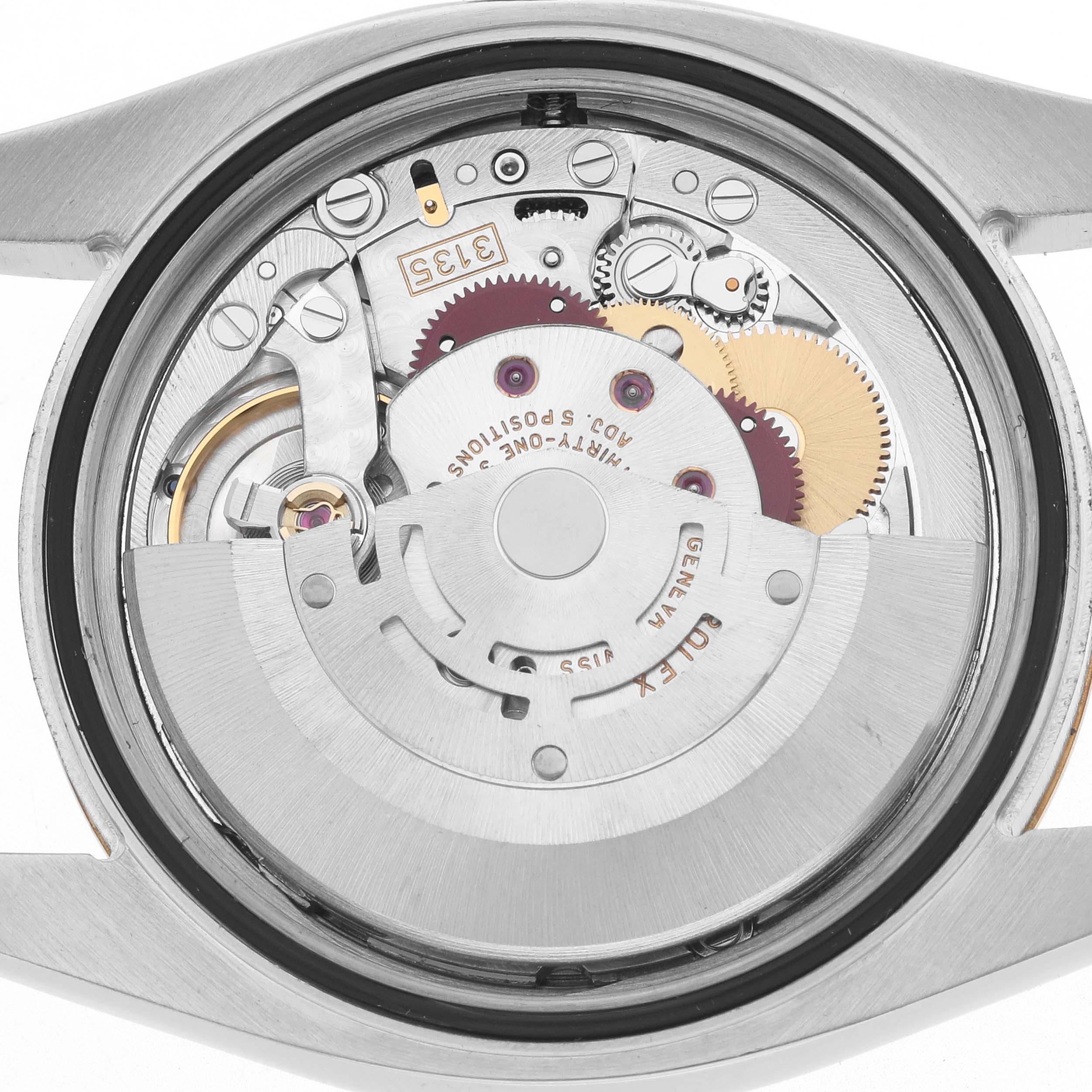 The image shows the movement of a Rolex Datejust 116233 Men
s Steel and Gold (two tone) Champagne Dial watch from a rear angle, highlighting gears and the rotor.