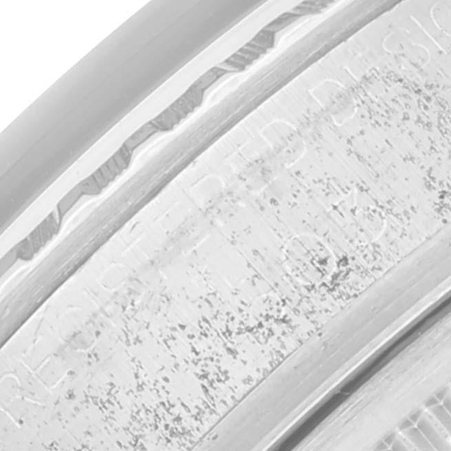 This image shows a close-up of the bezel with engraved text on a Rolex Vintage Collection 1603 Men's Stainless Steel Grey Dial 1603 Men's Stainless Steel Grey Dial watch.