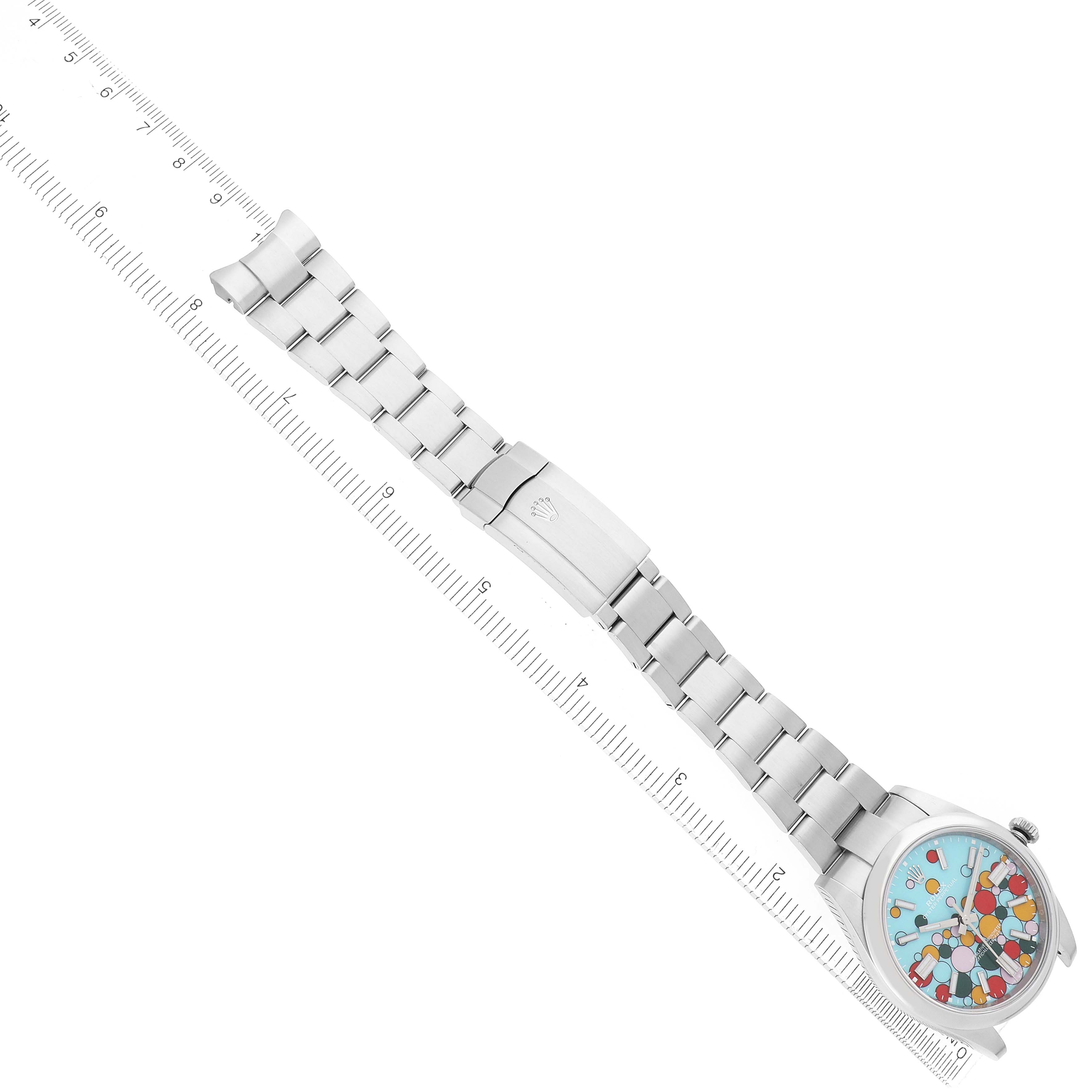 The Rolex Oyster Perpetual 124300 Men
s Stainless Steel Blue Dial watch is viewed from an elevated angle, showing the full bracelet, clasp, and colorful dial.