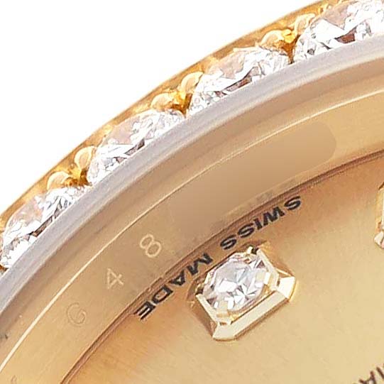 The image shows a close-up of the Rolex Pearlmaster 80298 Women's Yellow Gold Champagne Dial's bezel with diamonds and a partial view of the dial, showcasing a "Swiss Made" marking.