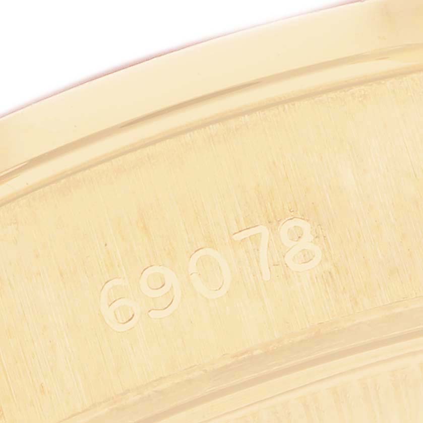 The image shows a close-up of the case back of a Rolex President 69078 Women
s Yellow Gold Champagne Dial, focusing on the model number engraving.