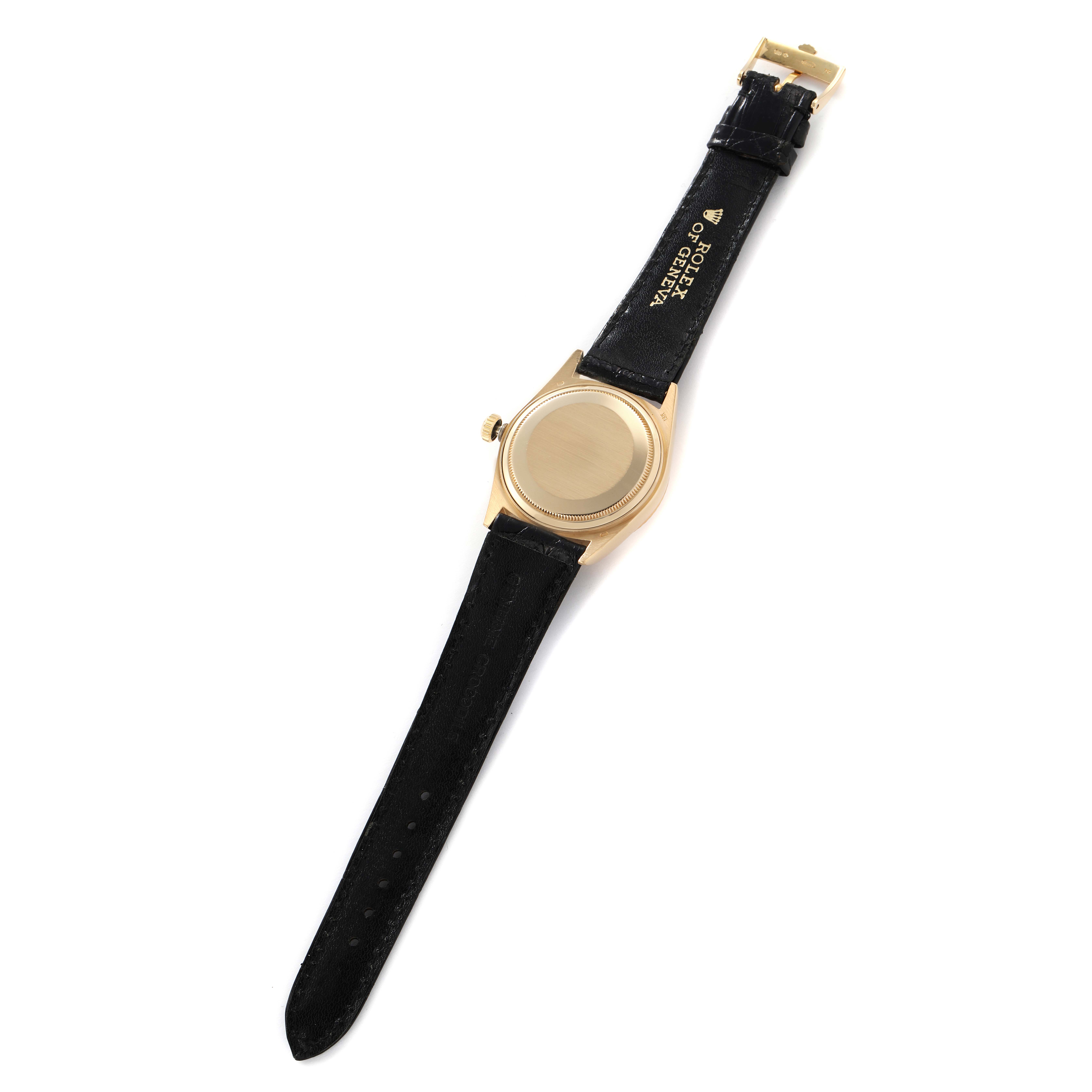 The image shows the back of a Rolex President 18038 Men
s Yellow Gold Champagne Dial watch and its black leather strap, emphasizing the case and buckle.