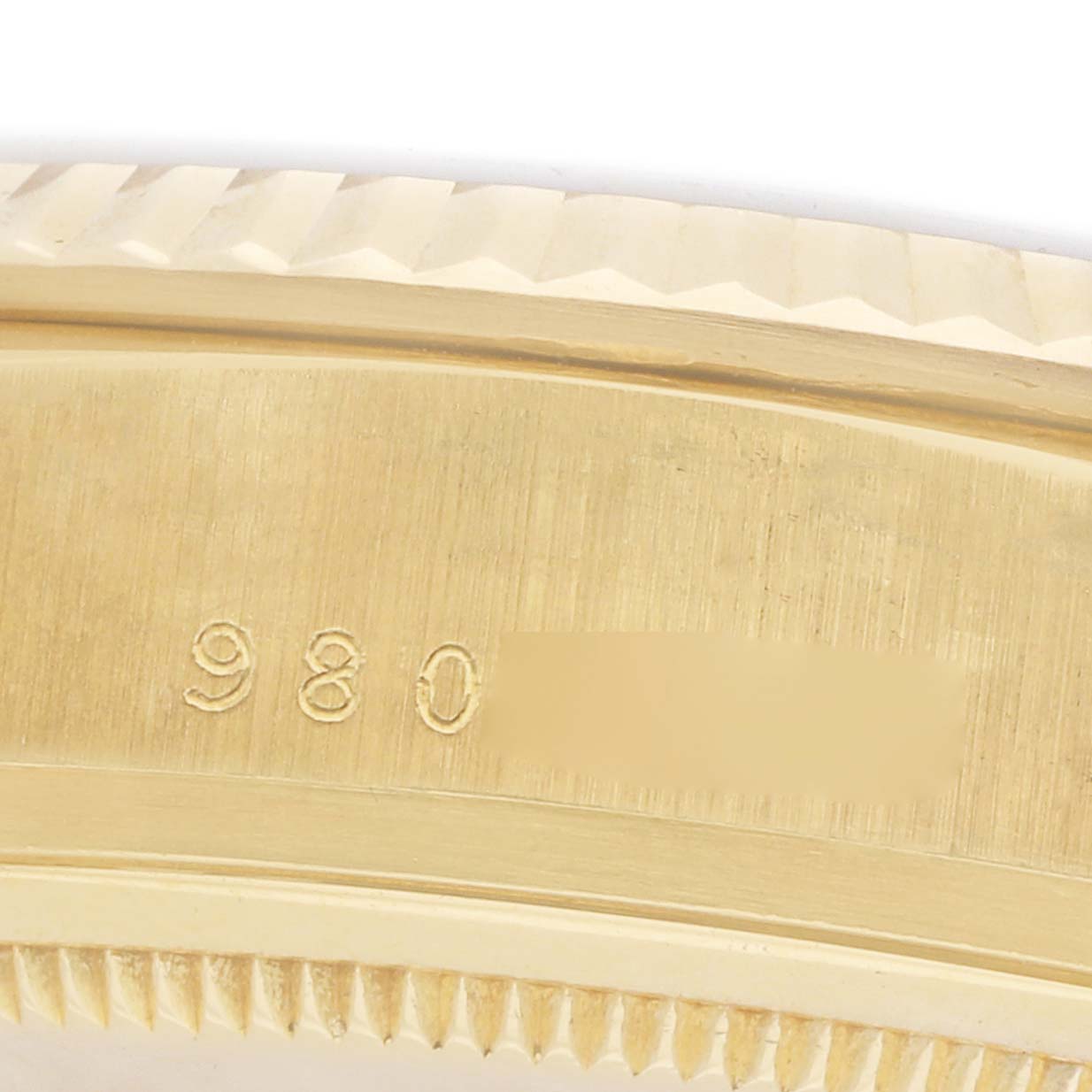 The image shows a close-up of the fluted bezel and engraved marking on a Rolex President 18038 Men
s Yellow Gold Champagne Dial watch case.