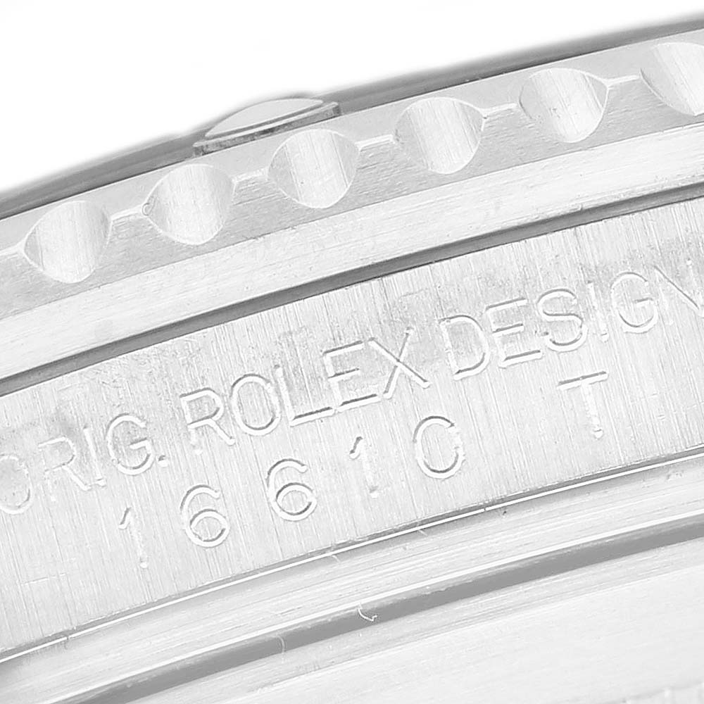 The image shows a close-up of the bezel and engraved details on a Rolex Submariner 16610 Men's Stainless Steel Black Dial watch.