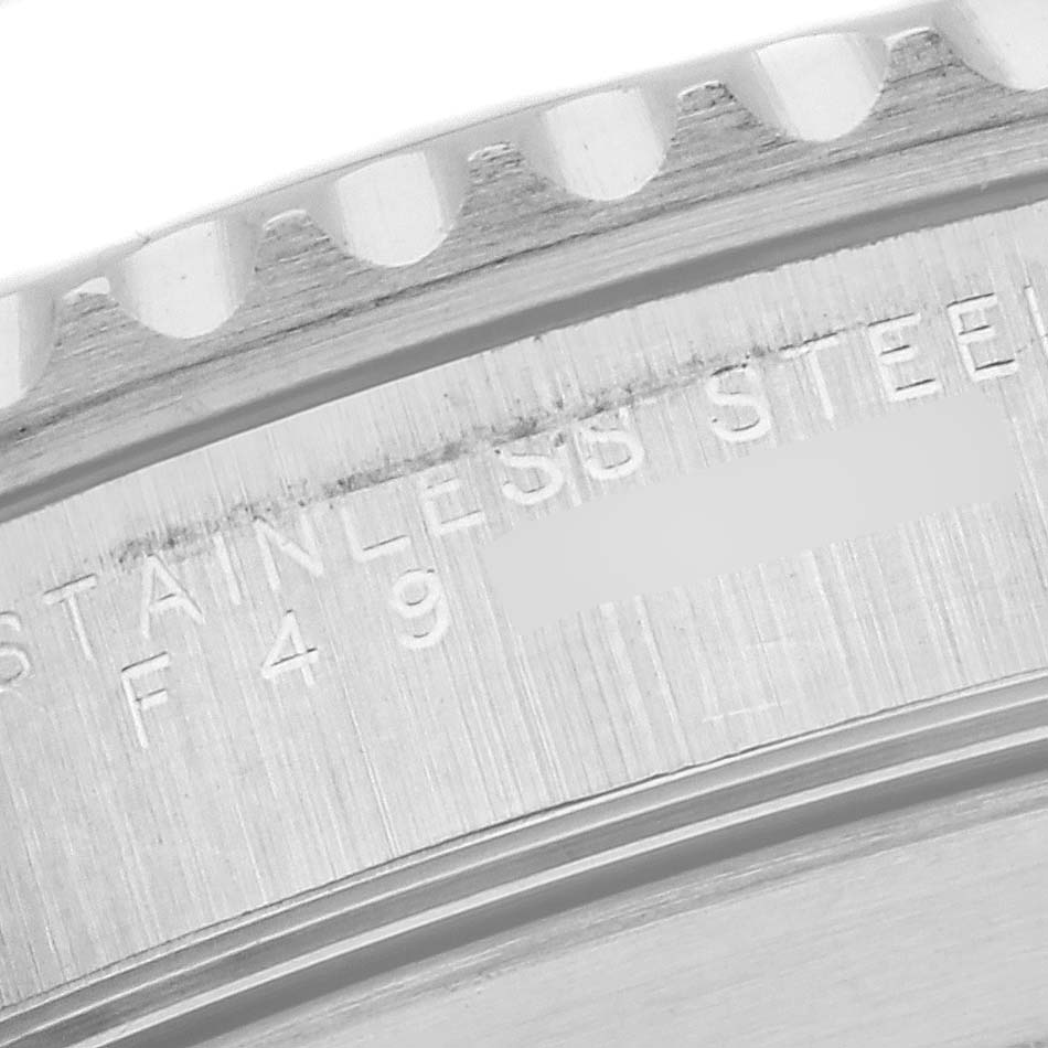 The image shows a close-up of the stainless steel case back and serrated edge of the bezel of a Rolex Submariner 14060M Men
s Stainless Steel Black Dial 14060M Men
s Stainless Steel Black Dial watch.