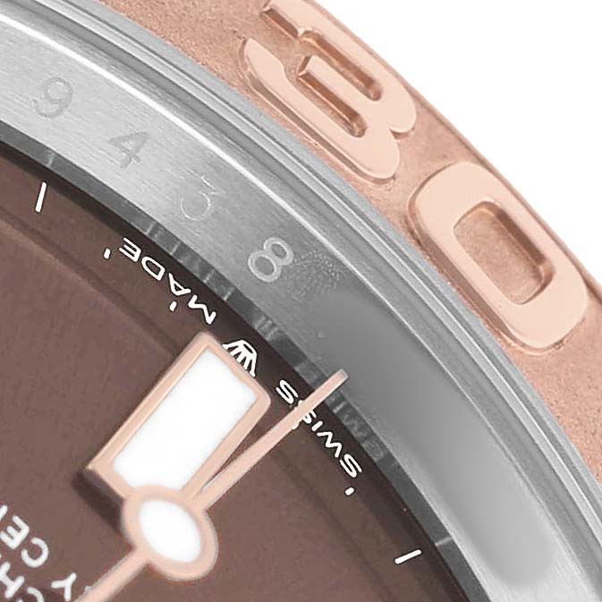 The image shows a close-up of a Rolex Yacht-Master 126621 Men's Stainless Steel Brown Dial watch, focusing on the bezel, part of the dial, and a hand.