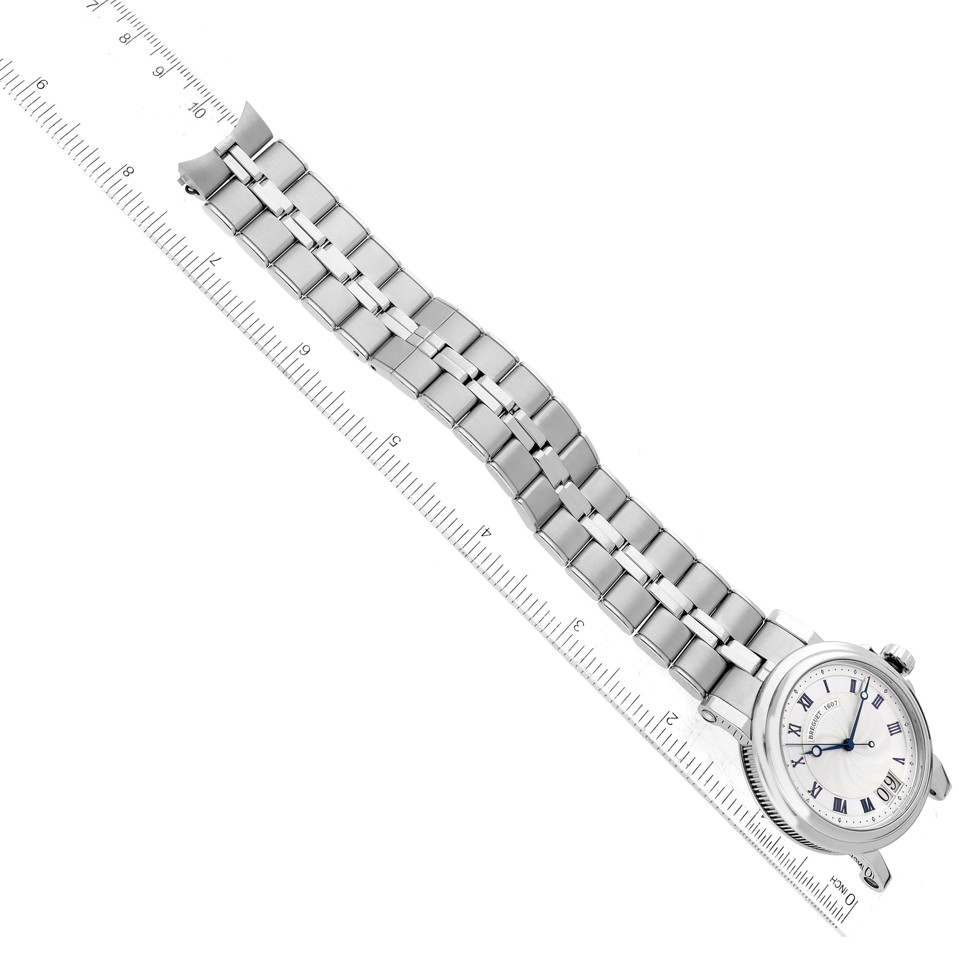 The Breguet Marine 5817ST/12/SM0 Men's Stainless Steel Silver Dial 5817ST/12/SM0 Men's Stainless Steel Silver Dial watch is shown from an overhead angle, featuring the bracelet and partial view of the watch face, next to a ruler.