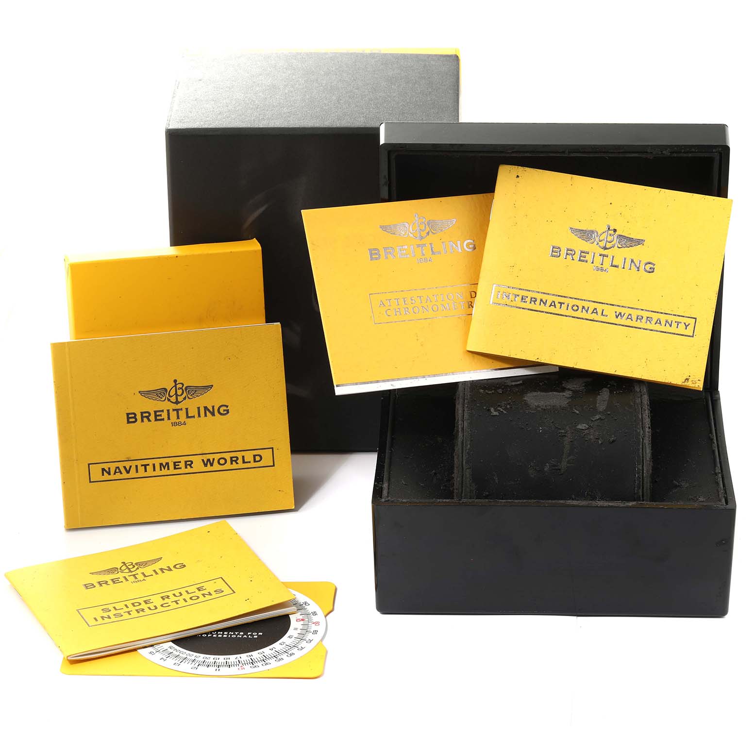 This image shows the packaging, warranty, manuals, and a slide rule for a Breitling Navitimer A24322 Men's Stainless Steel Black Dial A24322 Men's Stainless Steel Black Dial model watch.