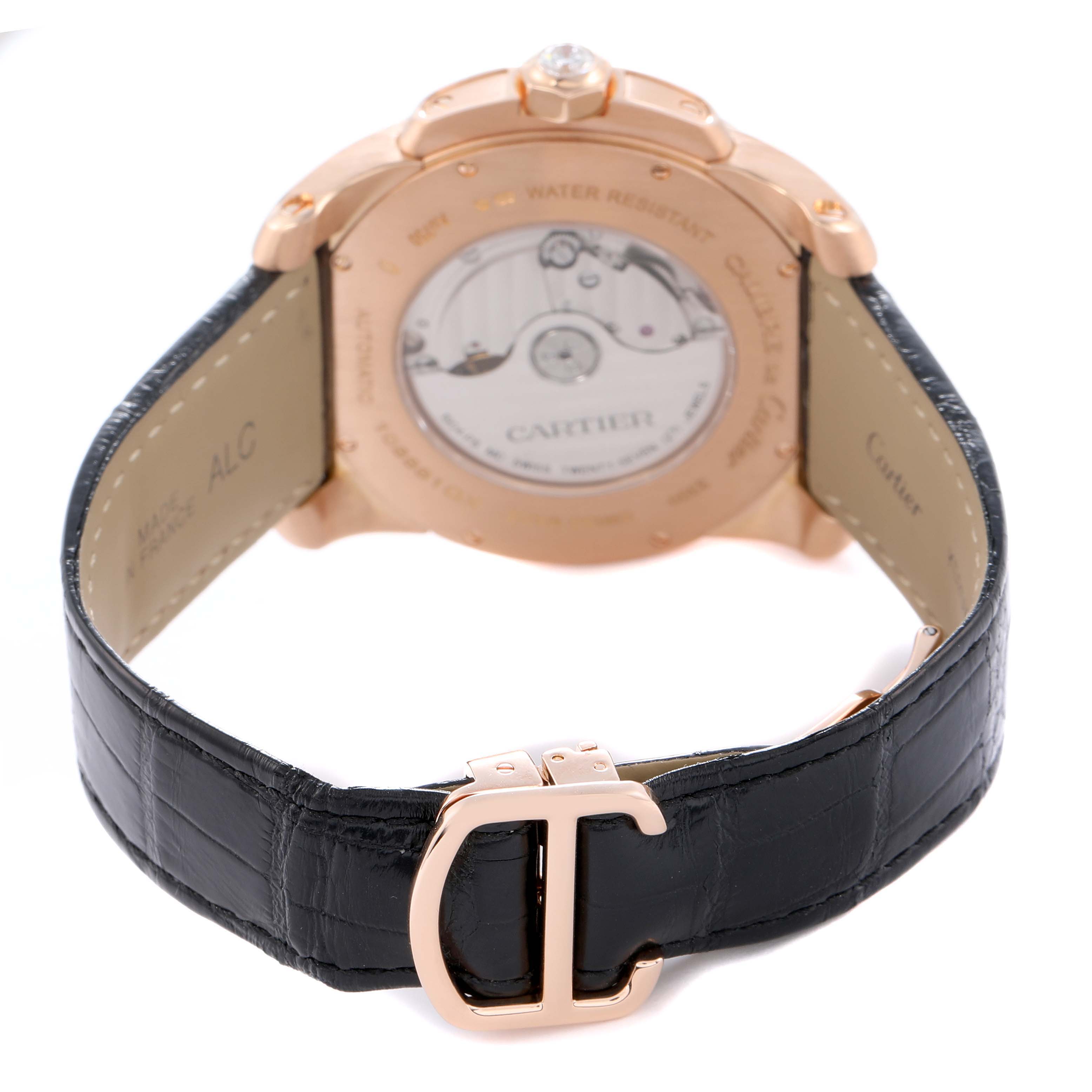 The image shows the back view of a Calibre de Cartier watch by Cartier, highlighting the mechanical movement and black leather strap.