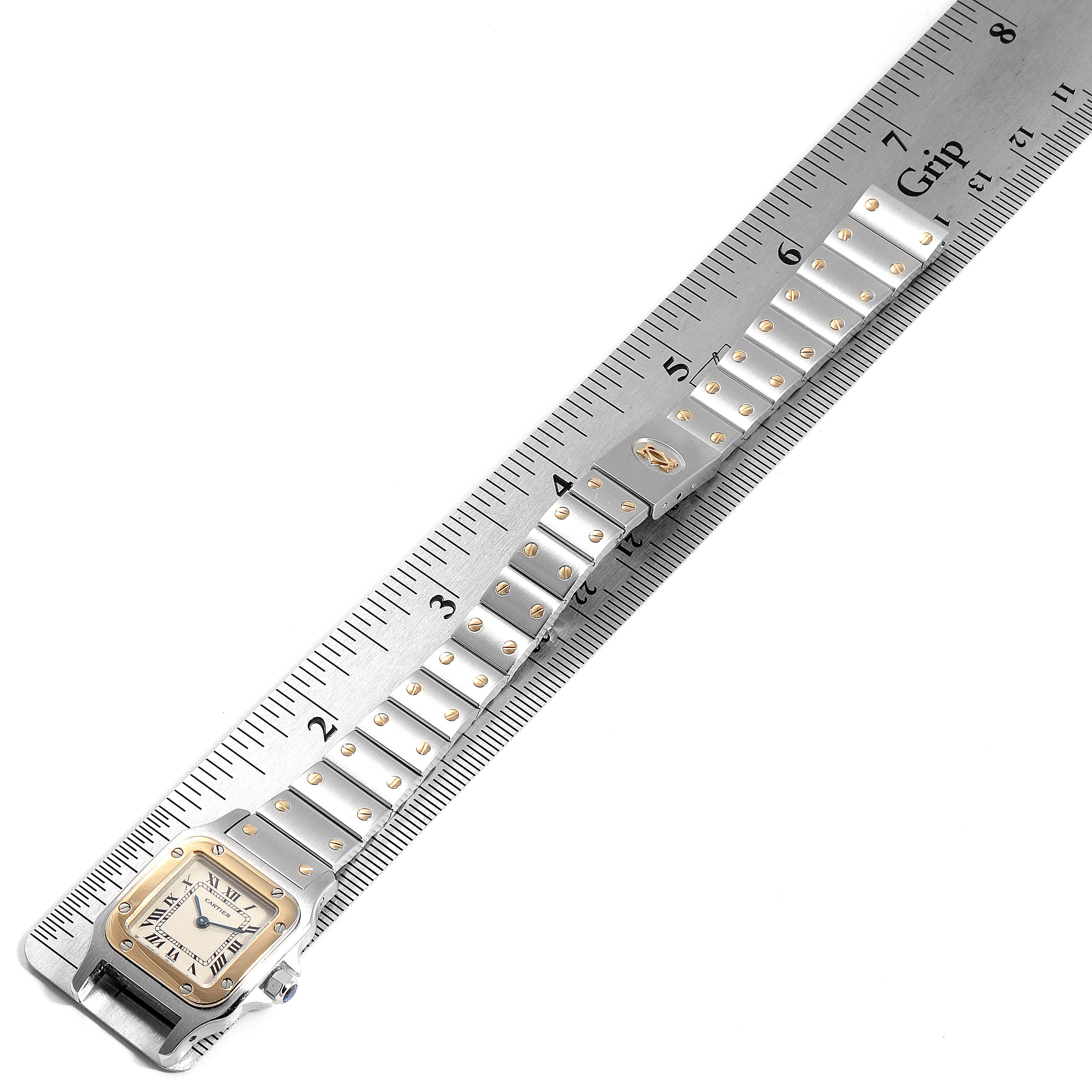 This image shows a Santos model Cartier watch from the front, highlighting its band and face against a ruler for measurement.
