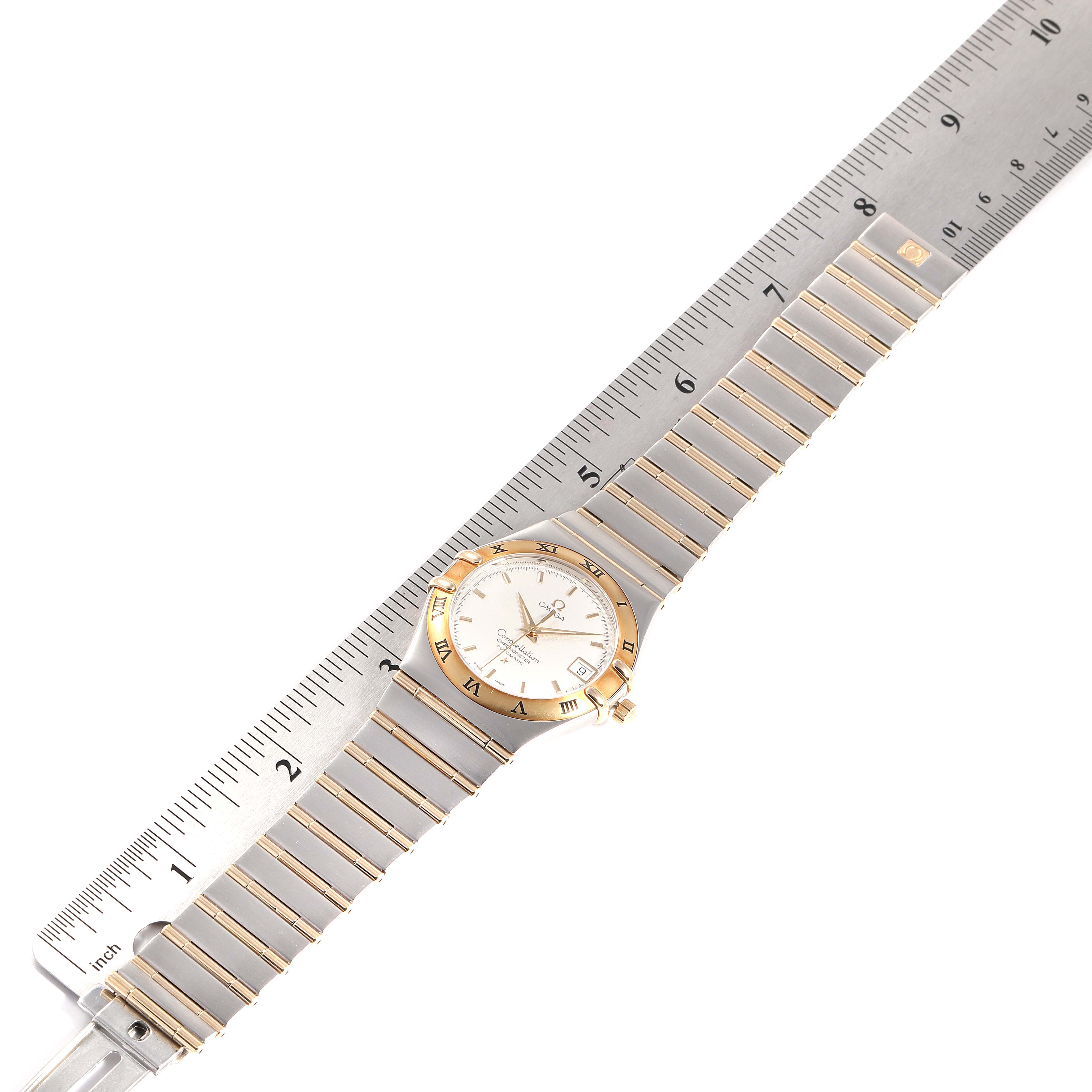 The Omega Constellation 1202.30.00 Men's Steel and Gold (two tone) Silver Dial 1202.30.00 Men's Steel and Gold (two tone) Silver Dial watch is shown flat with its band fully extended, alongside a ruler for reference.