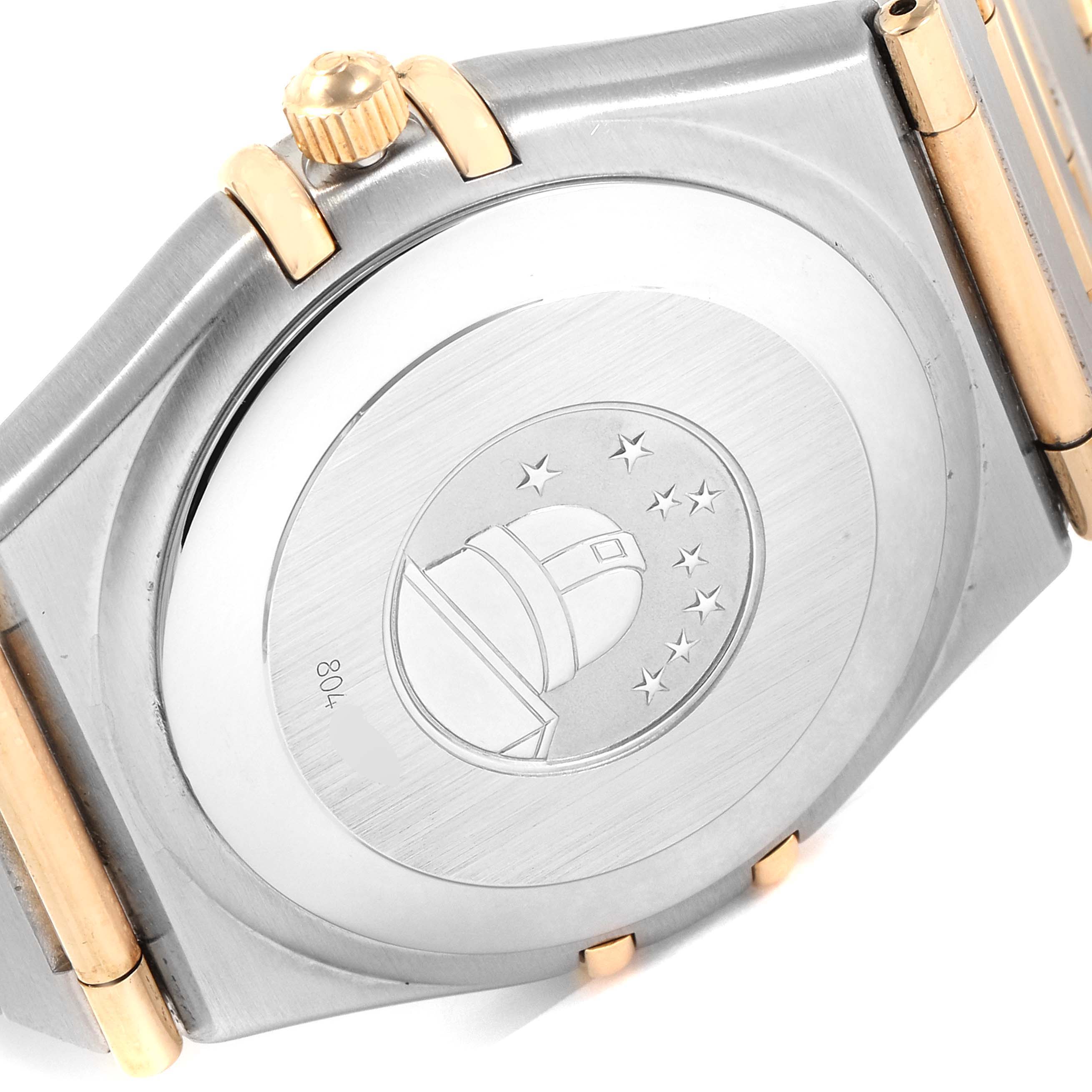 This image shows the back side and crown of an Omega Constellation 1202.30.00 Men's Steel and Gold (two tone) Silver Dial 1202.30.00 Men's Steel and Gold (two tone) Silver Dial watch, highlighting its embossed case back and two-tone design.