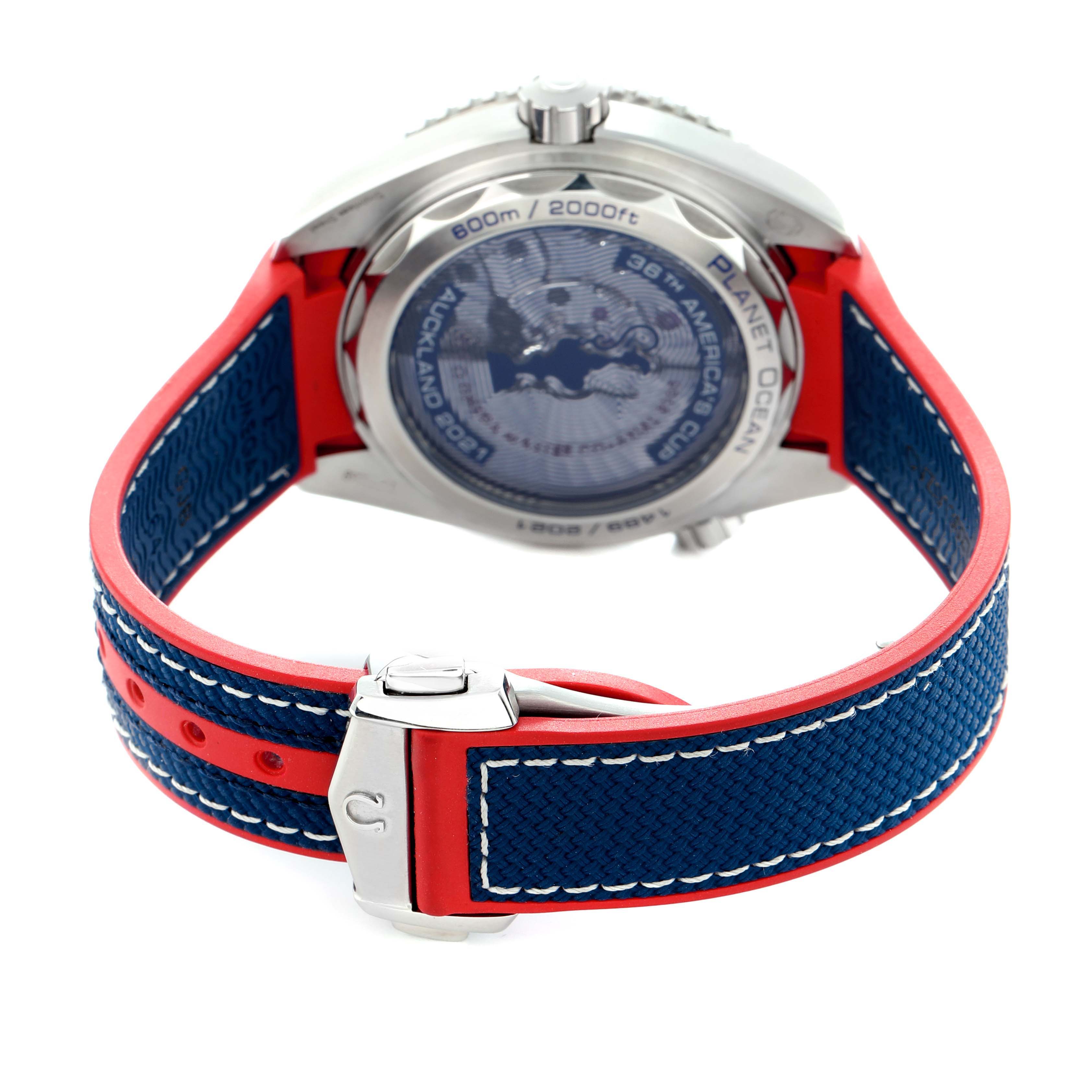 The image shows the back and strap of the Omega Planet Ocean 215.32.43.21.04.001 Men
s Stainless Steel White Dial watch with blue and red accents.