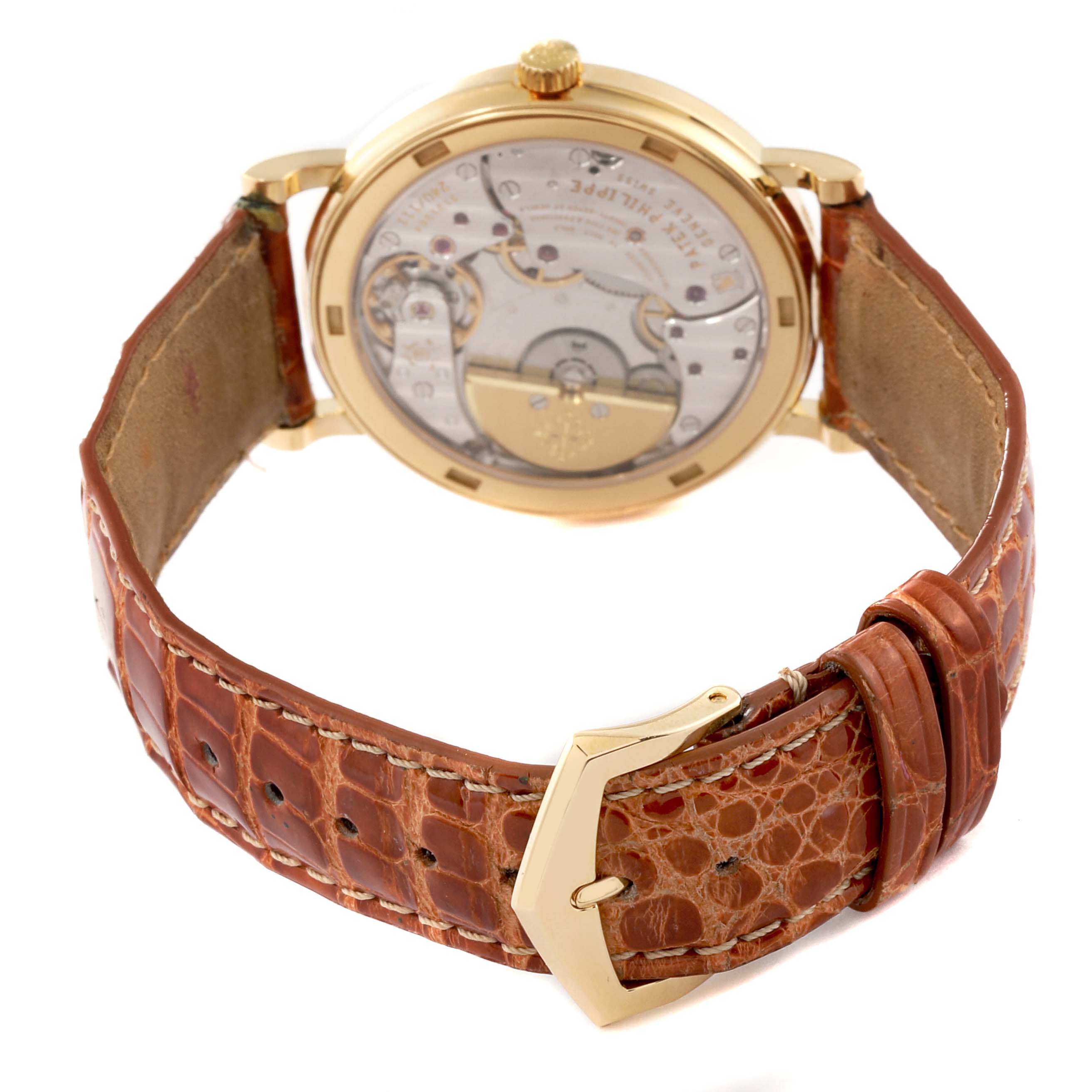 This image shows the back and strap of a Patek Philippe Calatrava 5120J-001 Men's Yellow Gold White Dial 5120J-001 Men's Yellow Gold White Dial watch, highlighting its mechanics and brown leather band.