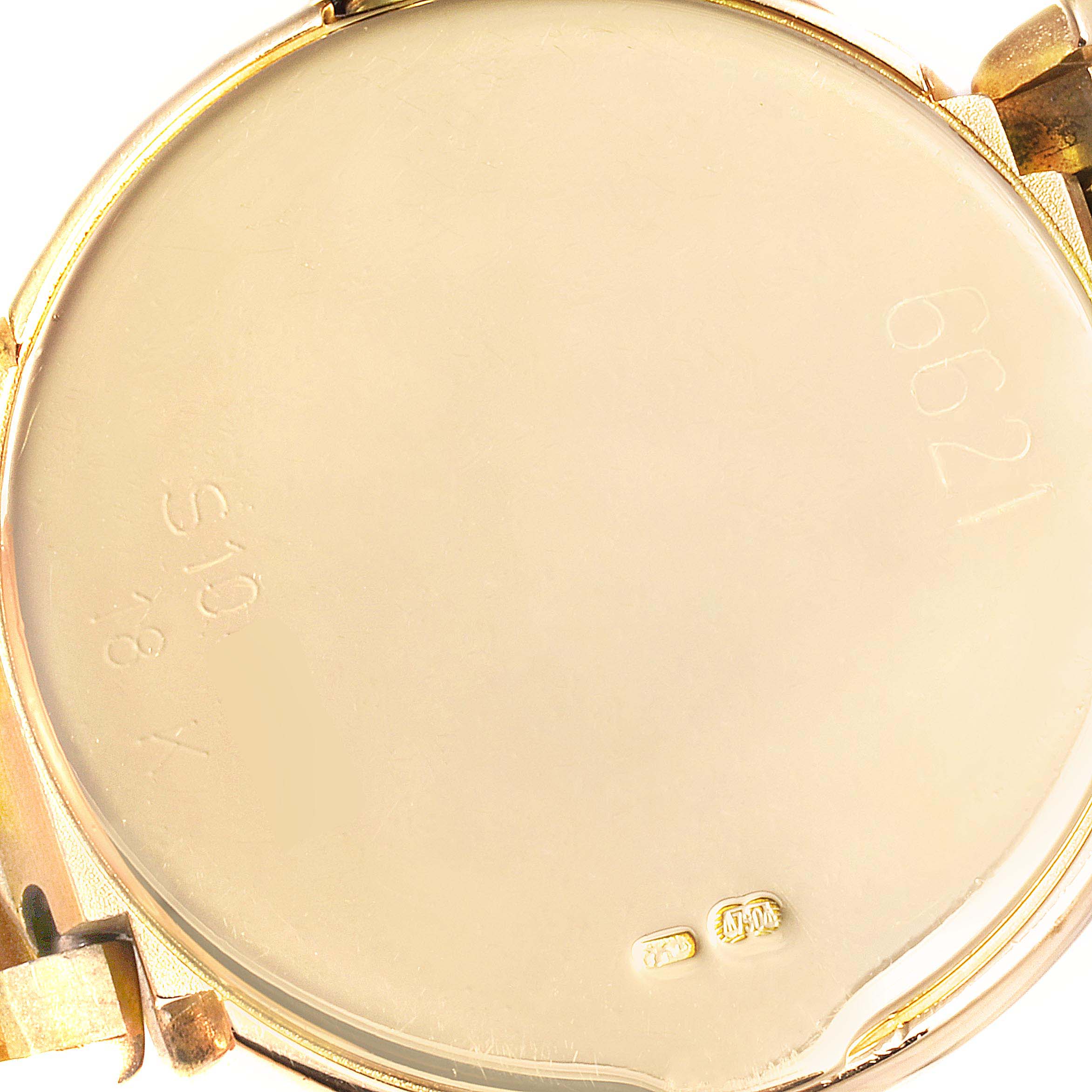 This image shows the back case of a Rolex Cellini 6621 Women's Yellow Gold Champagne Dial 6621 Women's Yellow Gold Champagne Dial watch at an angle displaying its engravings and hallmarks.