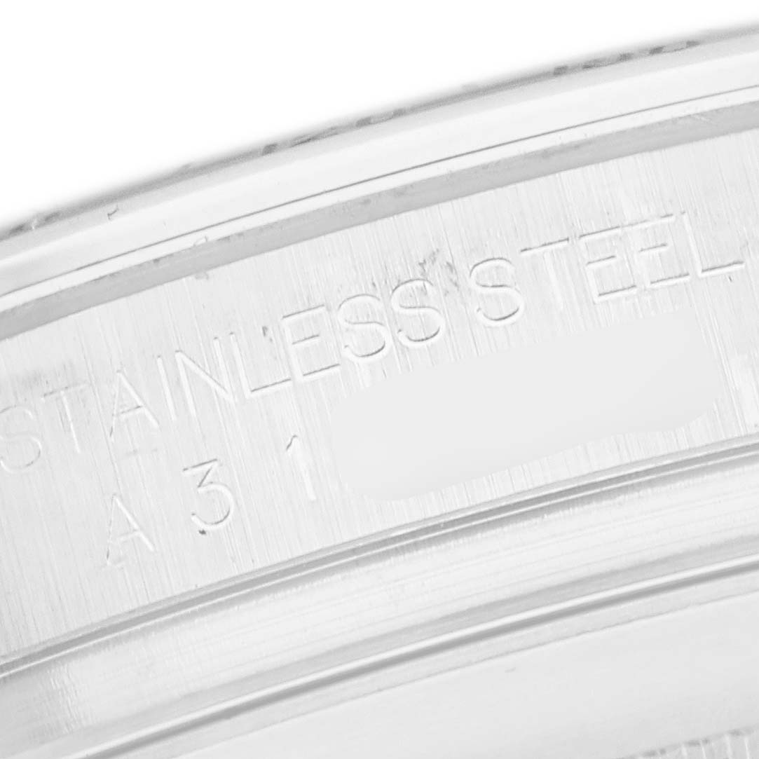 The image shows a close-up of the engraved edge of a Rolex Daytona 16520 Men
s Stainless Steel White Dial watch, highlighting the "STAINLESS STEEL" inscription.