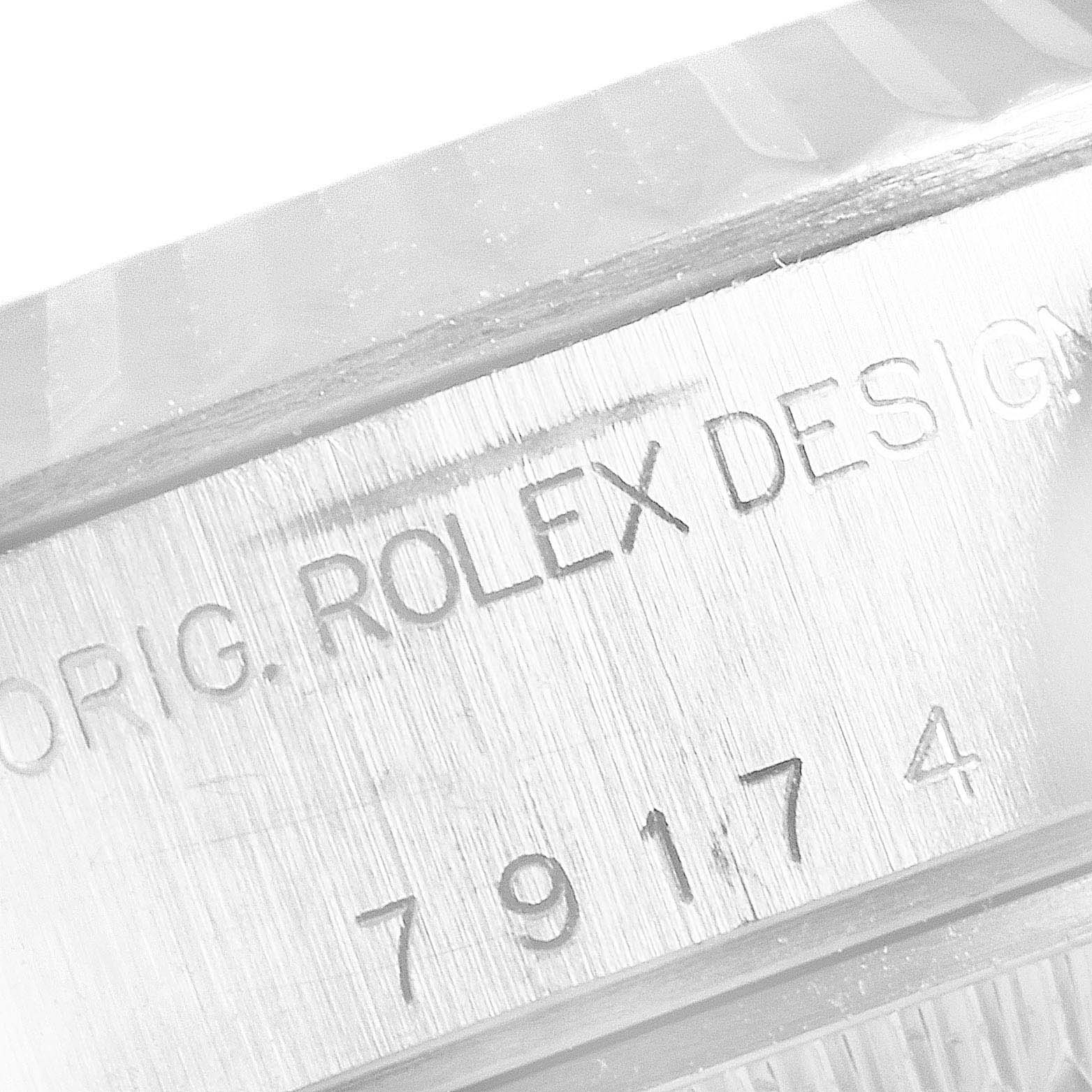 The image shows a close-up of the serial number and branding engraved on the case of a Rolex Datejust 79174 Women's Stainless Steel Black Dial 79174 Women's Stainless Steel Black Dial watch.