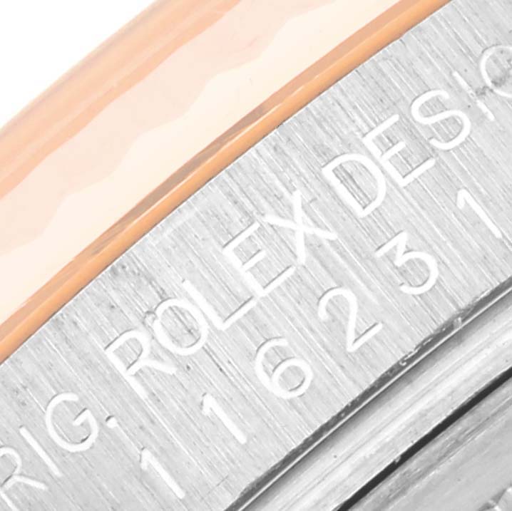 This close-up image shows a portion of the bezel and case side of a Rolex Datejust 116231 Men's Steel and Gold (two tone) Silver Dial 116231 Men's Steel and Gold (two tone) Silver Dial watch, highlighting its engraved text.