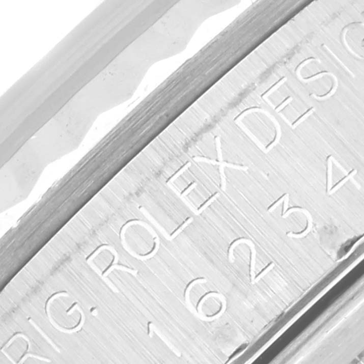 This close-up image of the Rolex Datejust 16234 Men's Stainless Steel Silver Dial 16234 Men's Stainless Steel Silver Dial watch showcases the engraved model number and part of the watch bezel.