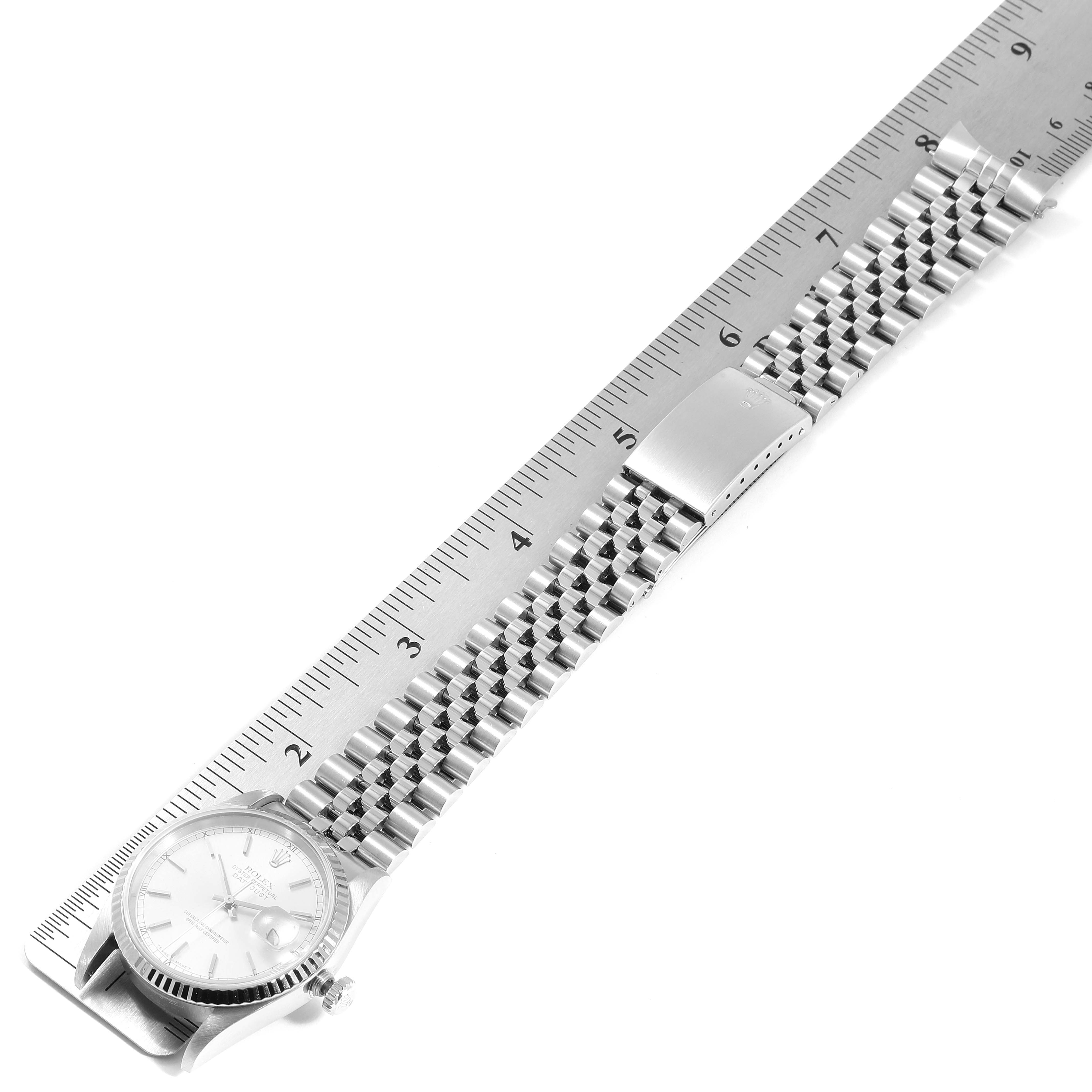 The image shows a top-down view of a Rolex Datejust 16234  Men's Stainless Steel Silver Dial 16234  Men's Stainless Steel Silver Dial watch with its face and bracelet aligned next to a ruler.