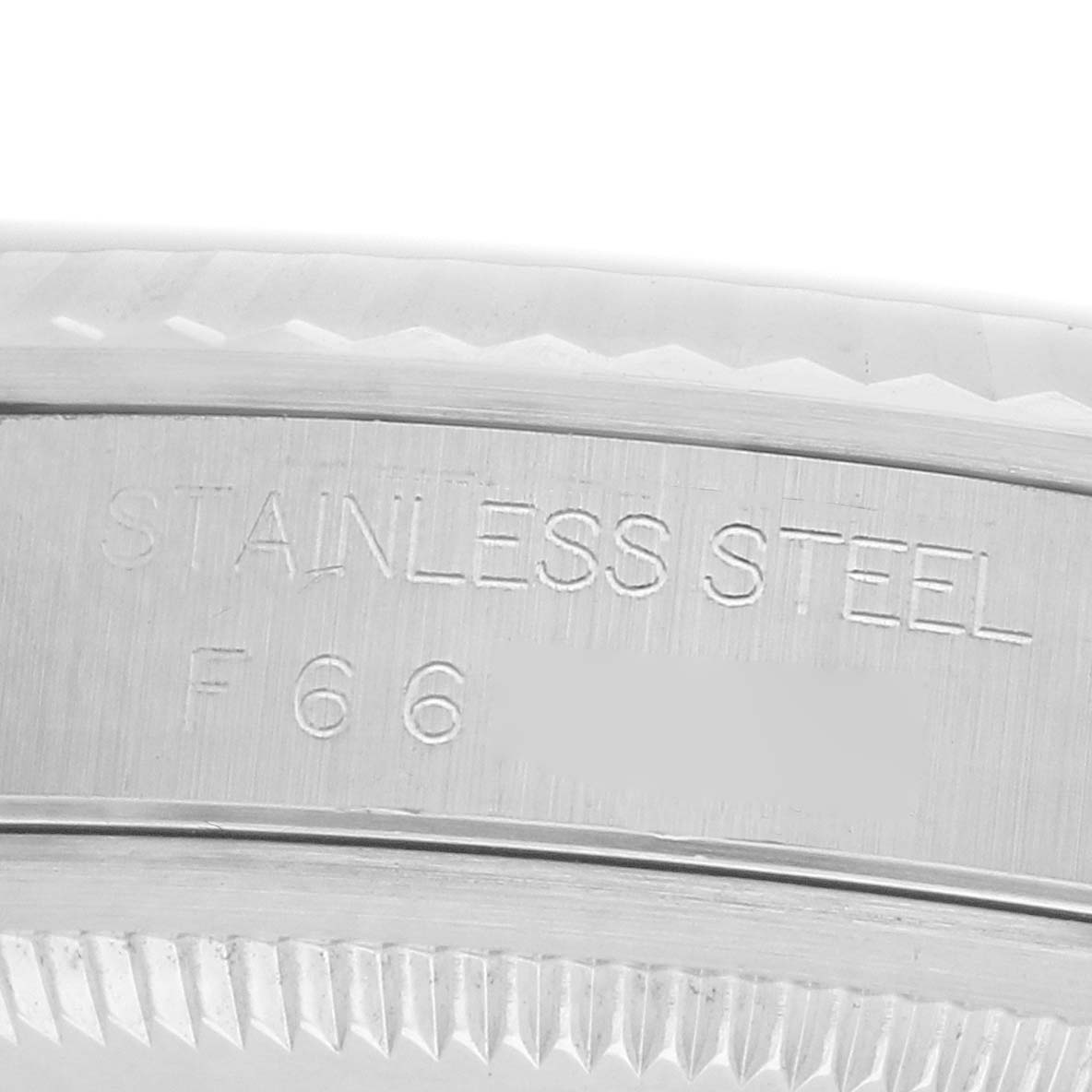 The image shows a close-up of the stainless steel case back edge of a Rolex Datejust 16234 Men
s Stainless Steel Silver Dial, revealing engraved details.