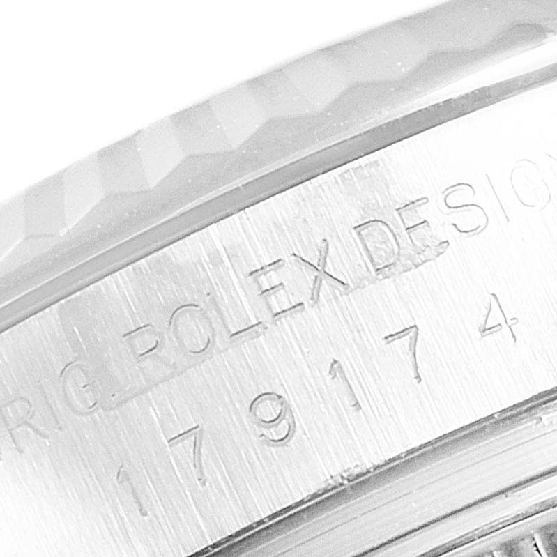 The image shows a close-up of the side of the case of a Rolex Datejust 179174  Women's Stainless Steel Black Dial 179174  Women's Stainless Steel Black Dial watch, highlighting the engraved serial number and part of the bezel.