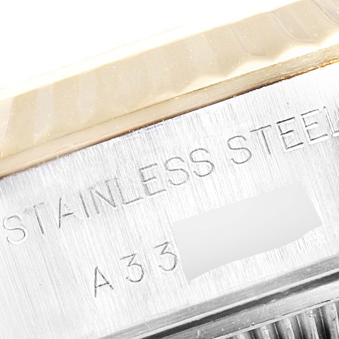 The image shows a close-up of the side of a Rolex Datejust 79173 Women's Steel and Gold (two tone) Champagne Dial 79173 Women's Steel and Gold (two tone) Champagne Dial watch, highlighting the stainless steel material and a partial serial number.