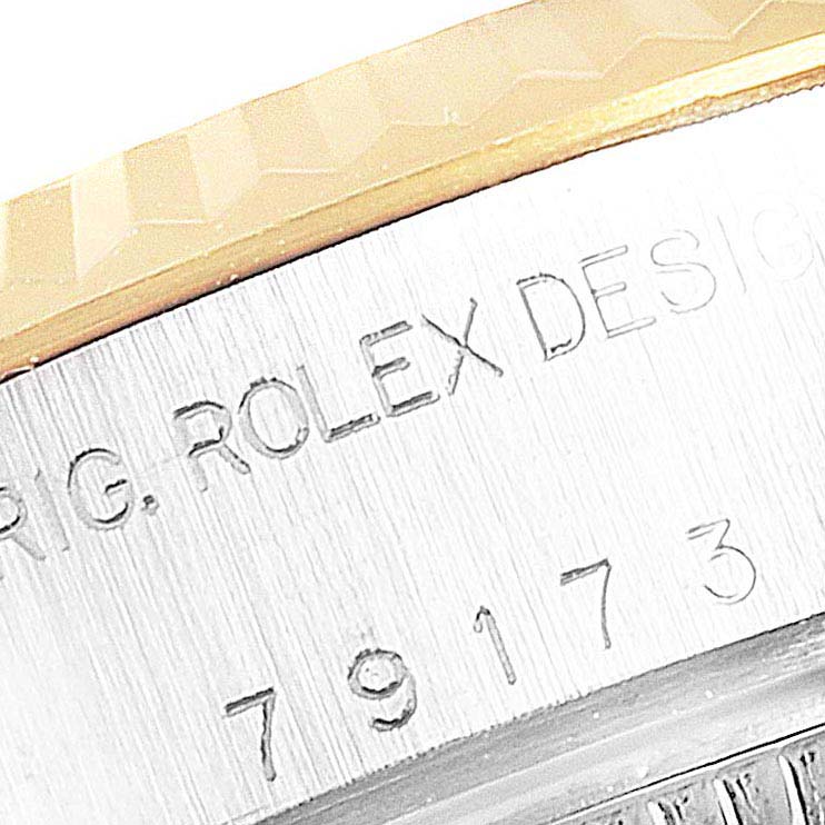 This close-up image shows the side engraving and part of the bezel of a Rolex Datejust 79173  Women
s Steel and Gold (two tone) Champagne Dial 79173  Women
s Steel and Gold (two tone) Champagne Dial watch.
