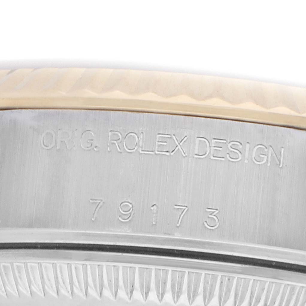 The image shows a close-up of the side of the Rolex Datejust 79173 Women
s Steel and Gold (two tone) Champagne Dial, highlighting the model number and "ORIG. ROLEX DESIGN" engraving.