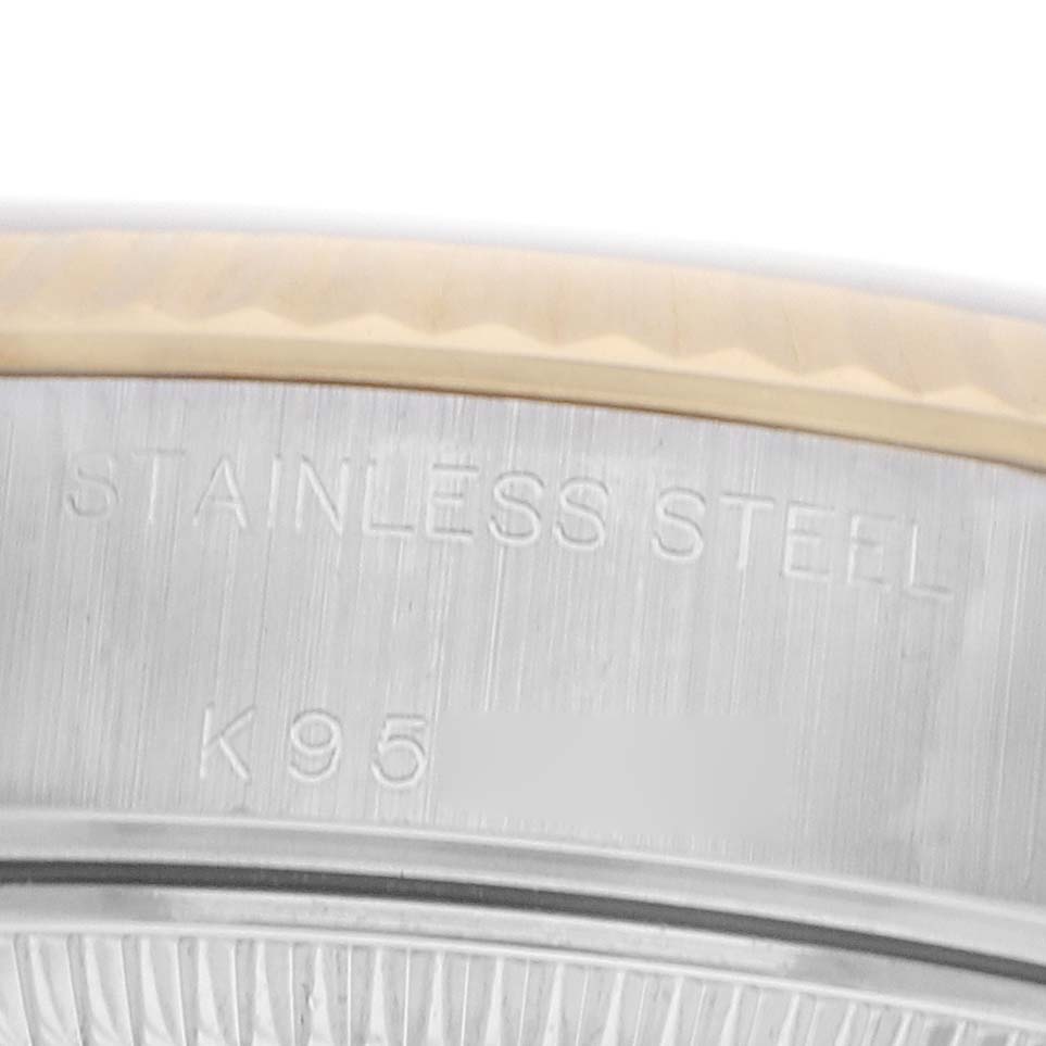 The image shows a close-up of the side of a Rolex Datejust 79173 Women
s Steel and Gold (two tone) Champagne Dial watch, featuring the engraved “STAINLESS STEEL” and part of the bezel.
