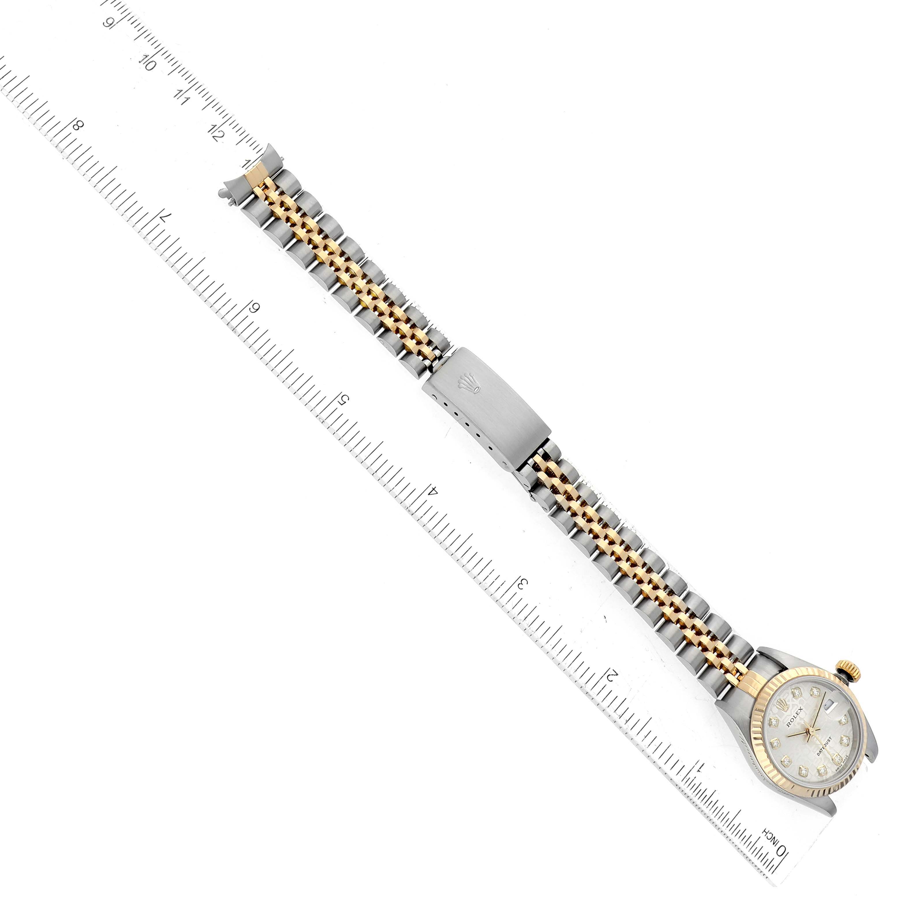 The image shows a Rolex Datejust 79173 Women's Steel and Gold (two tone) Silver Dial 79173 Women's Steel and Gold (two tone) Silver Dial watch with a two-tone metal bracelet, laying beside a ruler indicating the length.