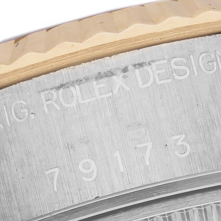 The image shows a close-up of the engraved bezel and side view of a Rolex Datejust 79173 Women's Steel and Gold (two tone) Silver Dial 79173 Women's Steel and Gold (two tone) Silver Dial watch.