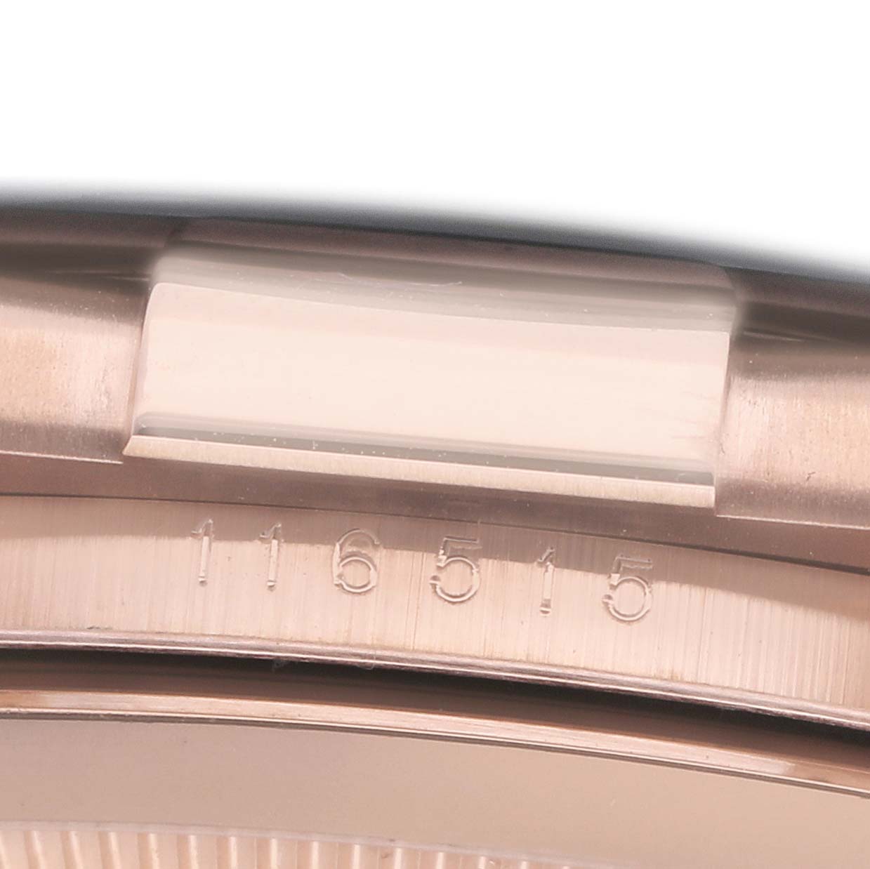 The image shows a close-up of the Rolex Daytona 116515 Men
s Rose Gold Black Dial bezel and the engraved model number "116515" beneath the crystal.