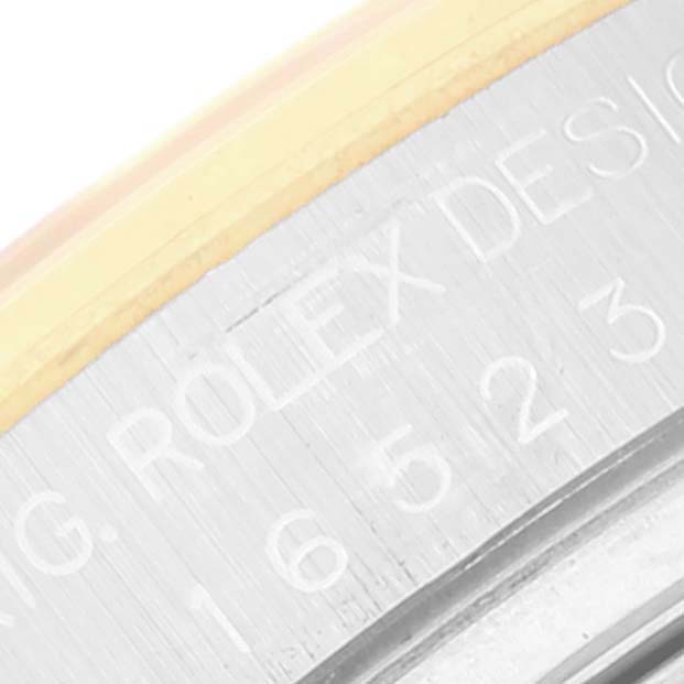 This close-up image shows the engraved side of a Rolex Daytona 16523 Men
s Steel and Gold (two tone) Black Dial 16523 Men
s Steel and Gold (two tone) Black Dial watch case, focusing on the model number and "Rolex Design" text.