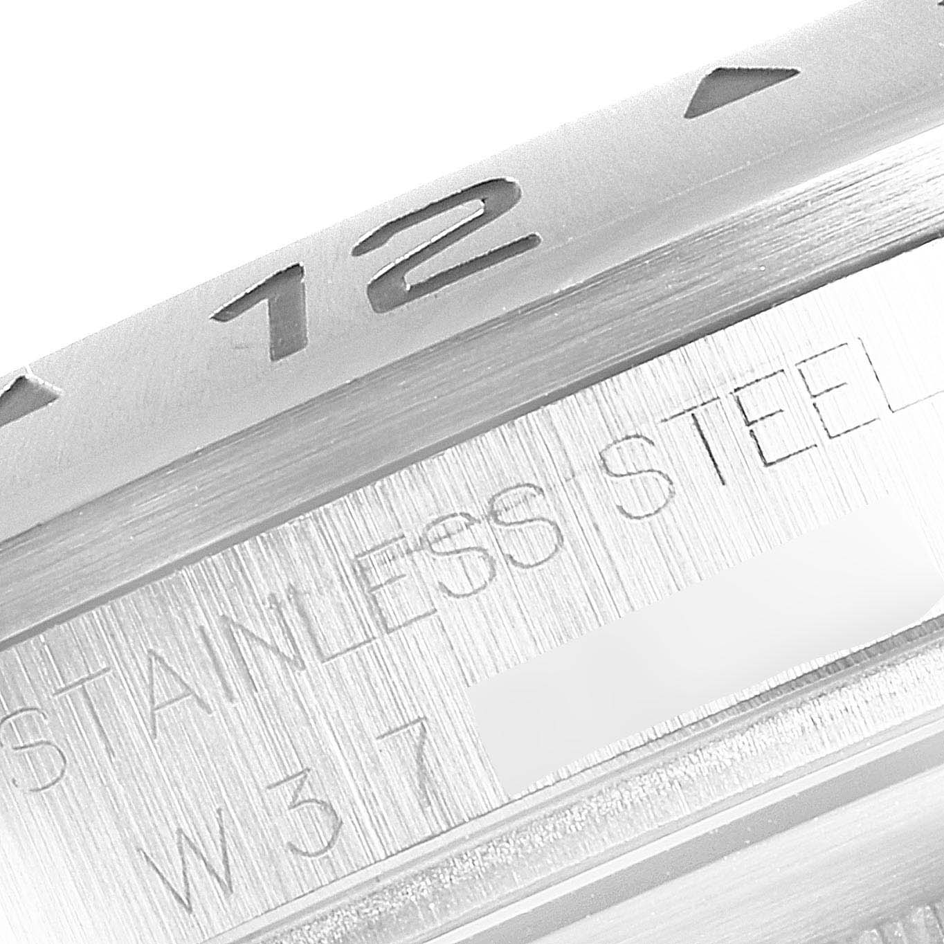 The image shows a close-up of the bezel and part of the casing of a Rolex Explorer 16570 Men
s Stainless Steel Black Dial 16570 Men
s Stainless Steel Black Dial watch, highlighting the number "12" and "STAINLESS STEEL."