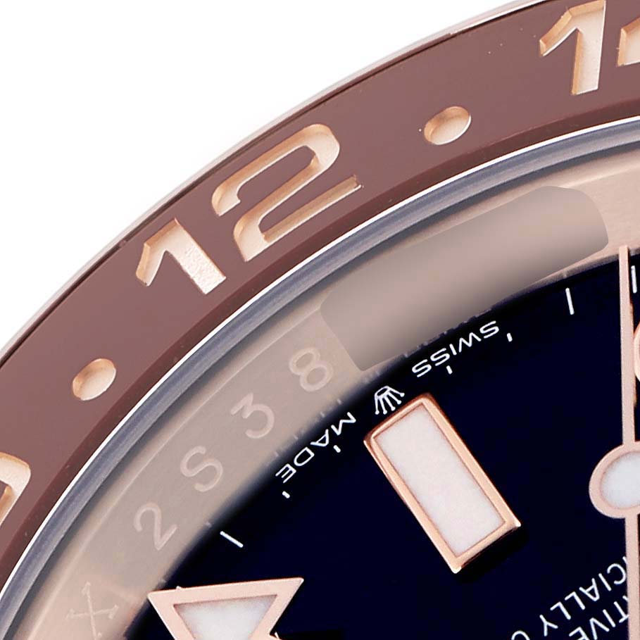 The image shows a close-up of the bezel and dial edge of a Rolex GMT-Master 126715 Men
s Rose Gold Black Dial watch, highlighting the numerals and part of the markers.