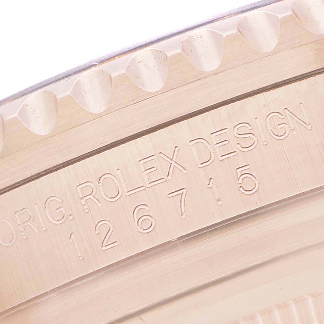 The angle shows a close-up of the serial number area on the bezel of the Rolex GMT-Master 126715 Men
s Rose Gold Black Dial.